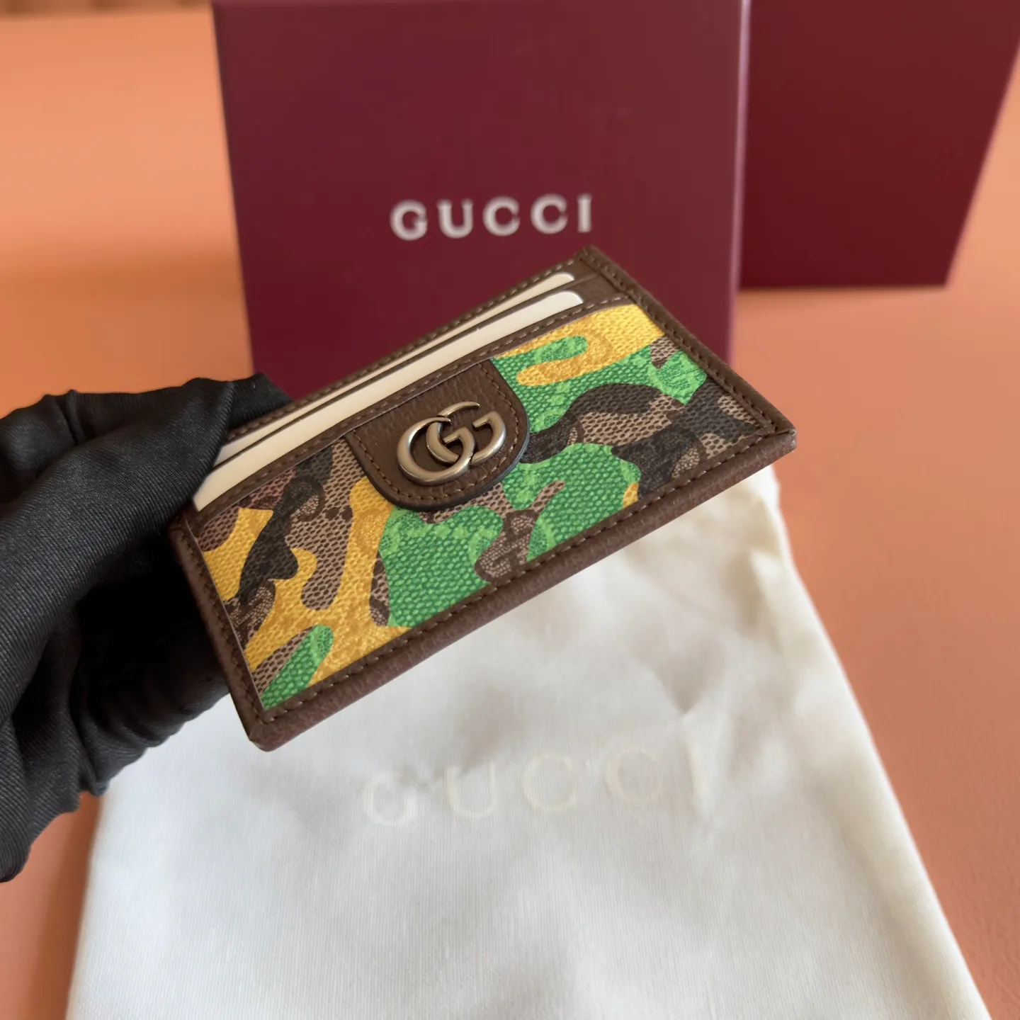 p300. 💋💋💋【With full set of original counter packaging】Vivid camouflage combined with unique color matching, a new interpretation of the classic GG pattern. This card holder is made of coated fabric with a marbled GG monogram pattern and features Double G details. Green and yellow camouflage marbled GG monogram coated fabric Brown leather trim Palladium tone hardware Brown taffeta lining Double G Web detail Interior: 1 open compartment Exterior: 4 card compartments Ident No.: 834795. Dimensions: 11cm (width) x 7cm (height) Weight: approx. 30g Color: green camouflage/pvc. Made in Italy