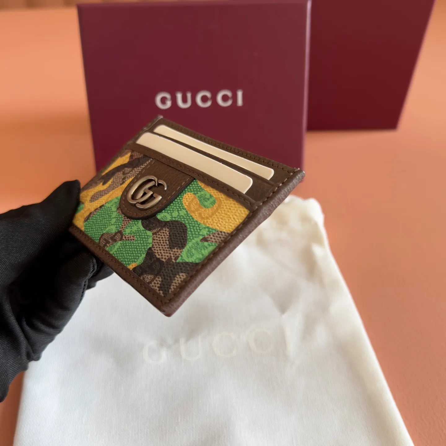 p300. 💋💋💋【With full set of original counter packaging】Vivid camouflage combined with unique color matching, a new interpretation of the classic GG pattern. This card holder is made of coated fabric with a marbled GG monogram pattern and features Double G details. Green and yellow camouflage marbled GG monogram coated fabric Brown leather trim Palladium tone hardware Brown taffeta lining Double G Web detail Interior: 1 open compartment Exterior: 4 card compartments Ident No.: 834795. Dimensions: 11cm (width) x 7cm (height) Weight: approx. 30g Color: green camouflage/pvc. Made in Italy