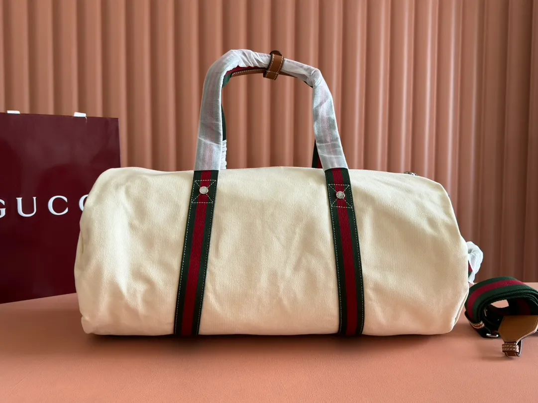 p1060. 💋💋💋"With a complete set of original counter gift bag packaging"💕[New Product] With the theme of freedom, vitality and community, the 2025 spring and summer series has newly presented a variety of travel items and men's bags, adding more fun to travel and exploration. This canvas travel bag features embellished stitching at the top, tonal leather piping and a 'Gucci Made in Italy' badge printed on the front. Off-white canvas Off-white leather trim "Gucci Made in Italy" and badge print Red and blue web Interior: 1 side handle Handle height: 24 cm Adjustable web canvas shoulder strap (55 cm high); length adjustable from 82 cm to 138 cm Zip closure Ident: 816866. Dimensions: 54cm (W) x 24cm (H) x 24cm (D) Weight: Approx. 0.985kg Colour: Off-white canvas. Made in Italy