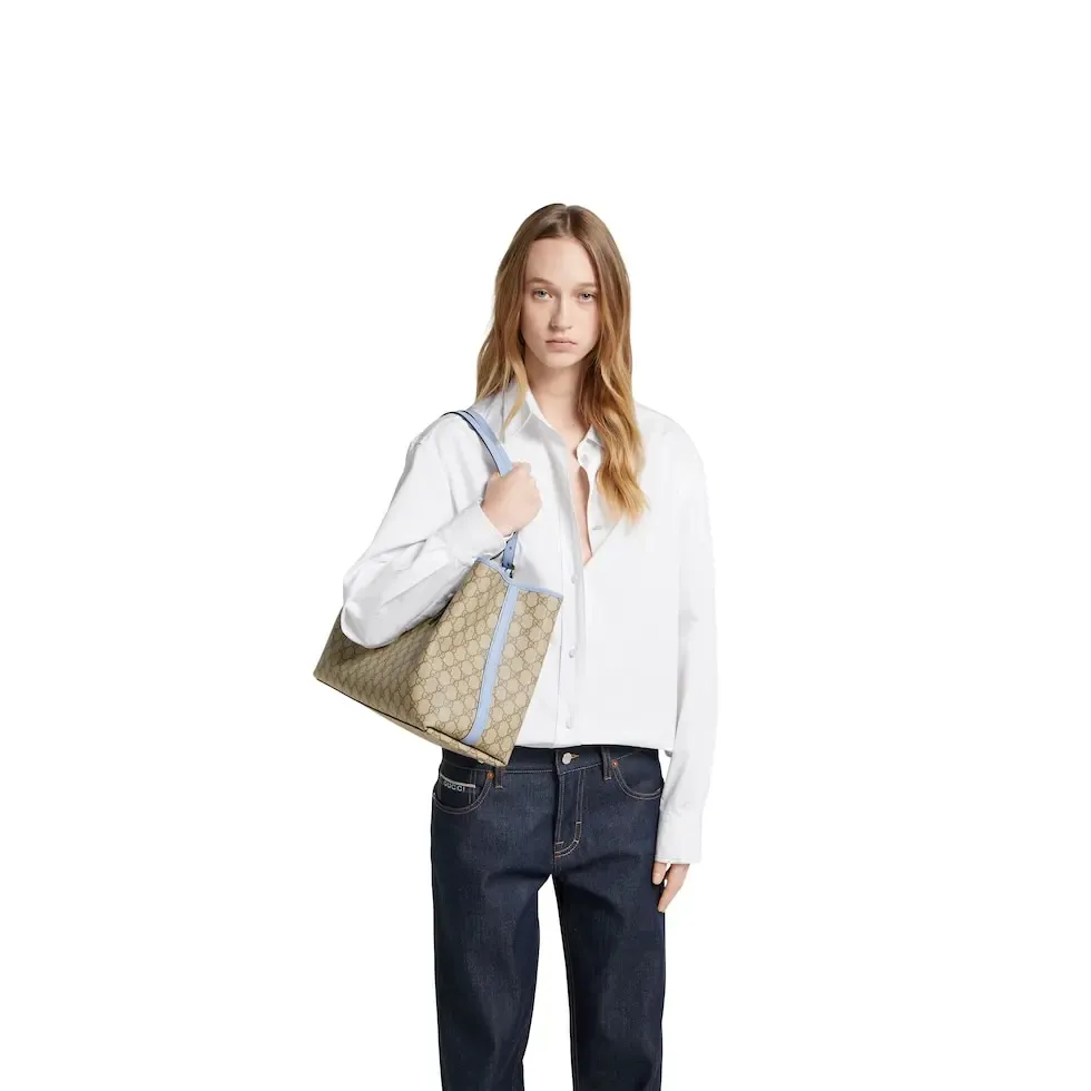 💕💕The GG Emblem series reinterprets the brand’s timeless elegance and exquisite craftsmanship. Inspired by the equestrian world, this tote bag features an adjustable top handle with numbered eyelets. New GG monogram coated fabric in beige and dark brown Light blue leather trim with contrast stitching Light gold tone hardware Red and green webbing cotton lining The bag pictured is sold separately and does not come with the bag charm. Also features D-ring for hanging removable items Adjustable handle with numbered eyelets (height: 21.5 cm - 31.5 cm) Interior: two compartments and one central zipped compartment Magnetic snap closure Ident.: 815213. Dimensions: 38cm (width) x 25cm (height) x 15cm (depth) Weight: about 0.85kg Color: brown pvc/original leather. Made in Italy