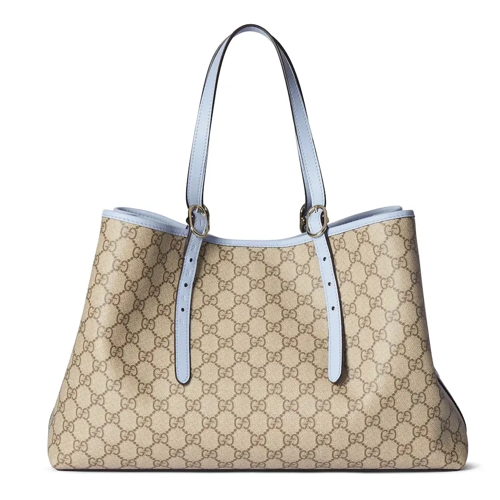 💕💕The GG Emblem series reinterprets the brand’s timeless elegance and exquisite craftsmanship. Inspired by the equestrian world, this tote bag features an adjustable top handle with numbered eyelets. New GG monogram coated fabric in beige and dark brown Light blue leather trim with contrast stitching Light gold tone hardware Red and green webbing cotton lining The bag pictured is sold separately and does not come with the bag charm. Also features D-ring for hanging removable items Adjustable handle with numbered eyelets (height: 21.5 cm - 31.5 cm) Interior: two compartments and one central zipped compartment Magnetic snap closure Ident.: 815213. Dimensions: 38cm (width) x 25cm (height) x 15cm (depth) Weight: about 0.85kg Color: brown pvc/original leather. Made in Italy