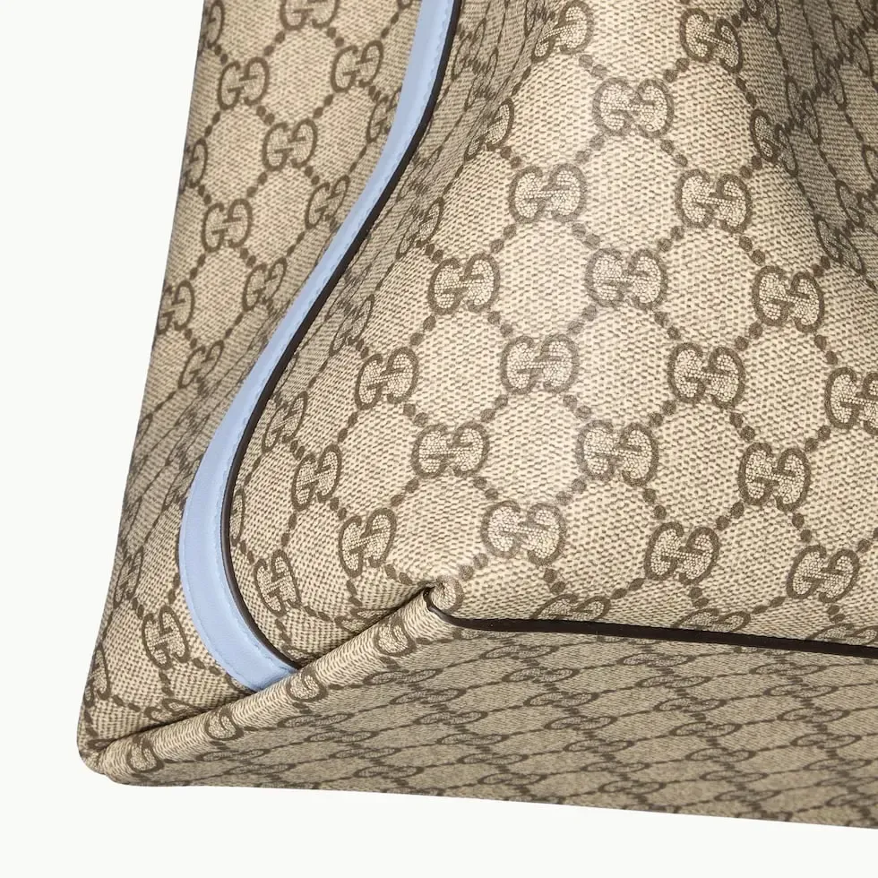 💕💕The GG Emblem series reinterprets the brand’s timeless elegance and exquisite craftsmanship. Inspired by the equestrian world, this tote bag features an adjustable top handle with numbered eyelets. New GG monogram coated fabric in beige and dark brown Light blue leather trim with contrast stitching Light gold tone hardware Red and green webbing cotton lining The bag pictured is sold separately and does not come with the bag charm. Also features D-ring for hanging removable items Adjustable handle with numbered eyelets (height: 21.5 cm - 31.5 cm) Interior: two compartments and one central zipped compartment Magnetic snap closure Ident.: 815213. Dimensions: 38cm (width) x 25cm (height) x 15cm (depth) Weight: about 0.85kg Color: brown pvc/original leather. Made in Italy