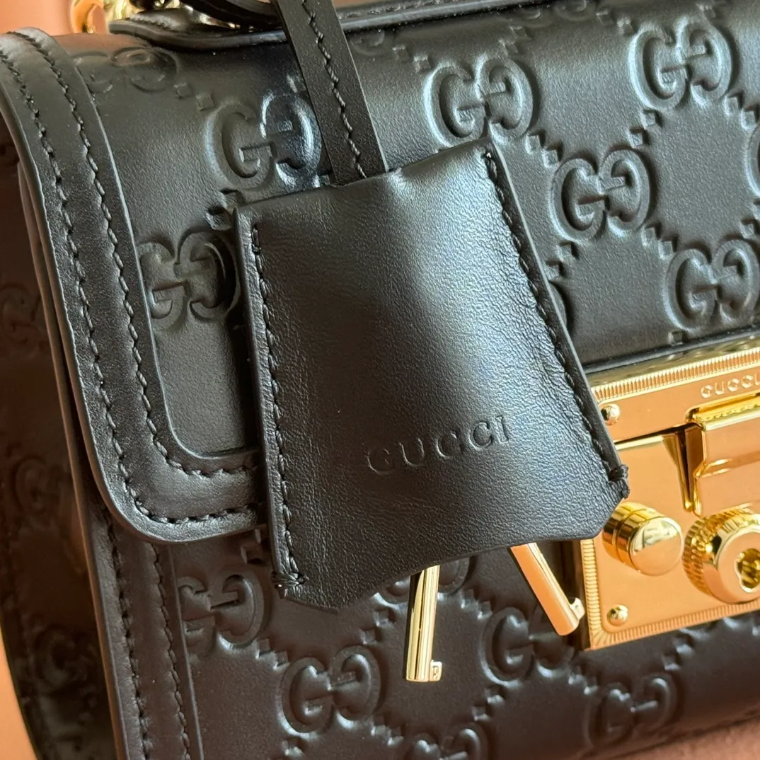p1240. 💋💋💋 Comes with a full set of original counter packaging [New product] The Padlock series makes a stunning appearance in the 2025 early autumn series with a modern silhouette, unlocking a variety of carrying methods. This style can be worn by hand or cross-body and has a web lining that pays homage to the brand's signature elements. Anchor red GG monogram coated fabric Anchor red leather piping Light gold-toned hardware Anchor red cotton lining Interior: one open pocket Outside: one open pocket Carry handles (6 cm height) Removable and adjustable leather shoulder strap (height: 57 cm – 62 cm; length: 103 cm – 123 cm) Padlock clasp with leather keychain Ident No.: 838999. Dimensions: 20cm (W) x 13cm (H) x 8cm (D) Weight: Approx. 0.6kg Colour: Black/Embossed. Made in Italy