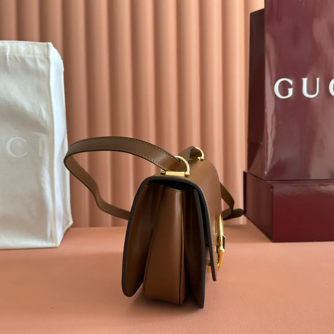 p1640. 💋💋💋【With full set of original counter packaging】2025 autumn and winter series, the Gucci Siena series small shoulder bag continues the evolution of the iconic element of Gucci's classic horsebit. Crafted from fine glossy leather, this shoulder bag has a structured shape and a half-horsebit buckle design from the 1970s. Finished with gold-tone hardware, the interior is lined with three levels of gusseting and a zipped pocket. Black fine glossy leather Gold-tone hardware Black leather lining Interior: 3-level fastening and 1 zipped pocket Shoulder straps: Height: 23cm – 25cm; Length: 127cm Half-horsebit snap fastener Ident: 846705. Dimensions: 22.5cm (width) x 14cm (height) x 8cm (depth) Weight: approx. 0.7kg Color: brown full leather. Made in Italy