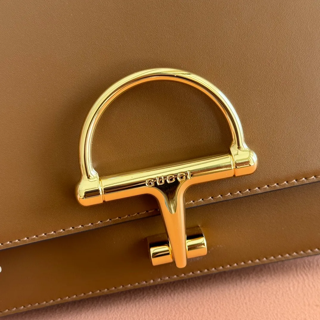 p1640. 💋💋💋【With full set of original counter packaging】2025 autumn and winter series, the Gucci Siena series small shoulder bag continues the evolution of the iconic element of Gucci's classic horsebit. Crafted from fine glossy leather, this shoulder bag has a structured shape and a half-horsebit buckle design from the 1970s. Finished with gold-tone hardware, the interior is lined with three levels of gusseting and a zipped pocket. Black fine glossy leather Gold-tone hardware Black leather lining Interior: 3-level fastening and 1 zipped pocket Shoulder straps: Height: 23cm – 25cm; Length: 127cm Half-horsebit snap fastener Ident: 846705. Dimensions: 22.5cm (width) x 14cm (height) x 8cm (depth) Weight: approx. 0.7kg Color: brown full leather. Made in Italy