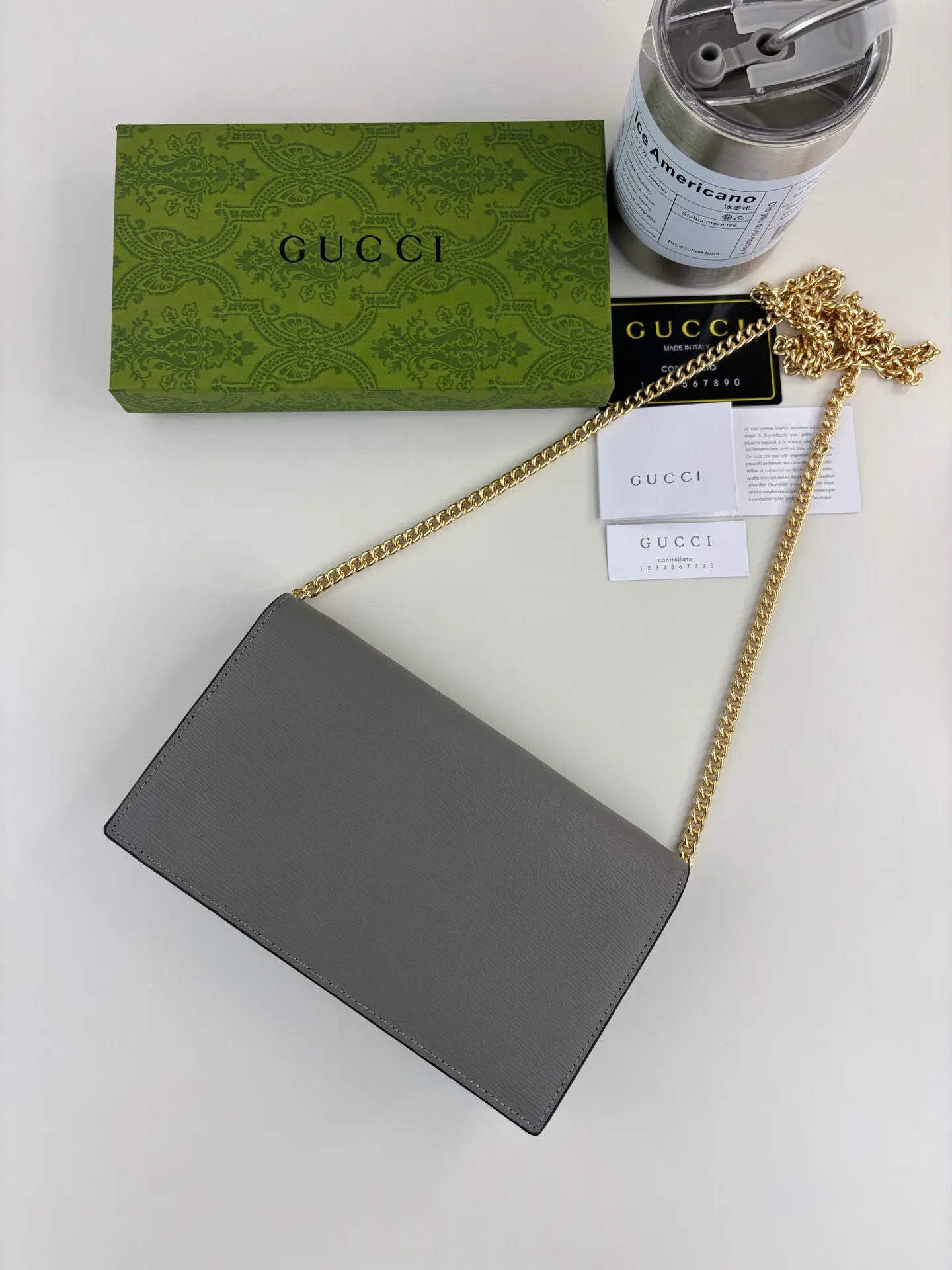 💰230 GUCCl chain wallet with handwritten Gucci logo. The small leather accessories series seamlessly integrates modern fashion elements to create ingenious items with changing styles without losing classic connotation, bringing fresh vitality to formal leather items. This chain wallet is crafted from gray leather and features the Gucci logo in gold-tone script. Gray leather, gold-tone hardware, taffeta lining, scripted Gucci logo detail, interior: six card compartments, one flat pocket, one zipped gusset pocket and one open compartment, chain strap, snap-stud fastening. Style number: 772643 Size: 20cm x 12.5cm x 4cm Color: Gray