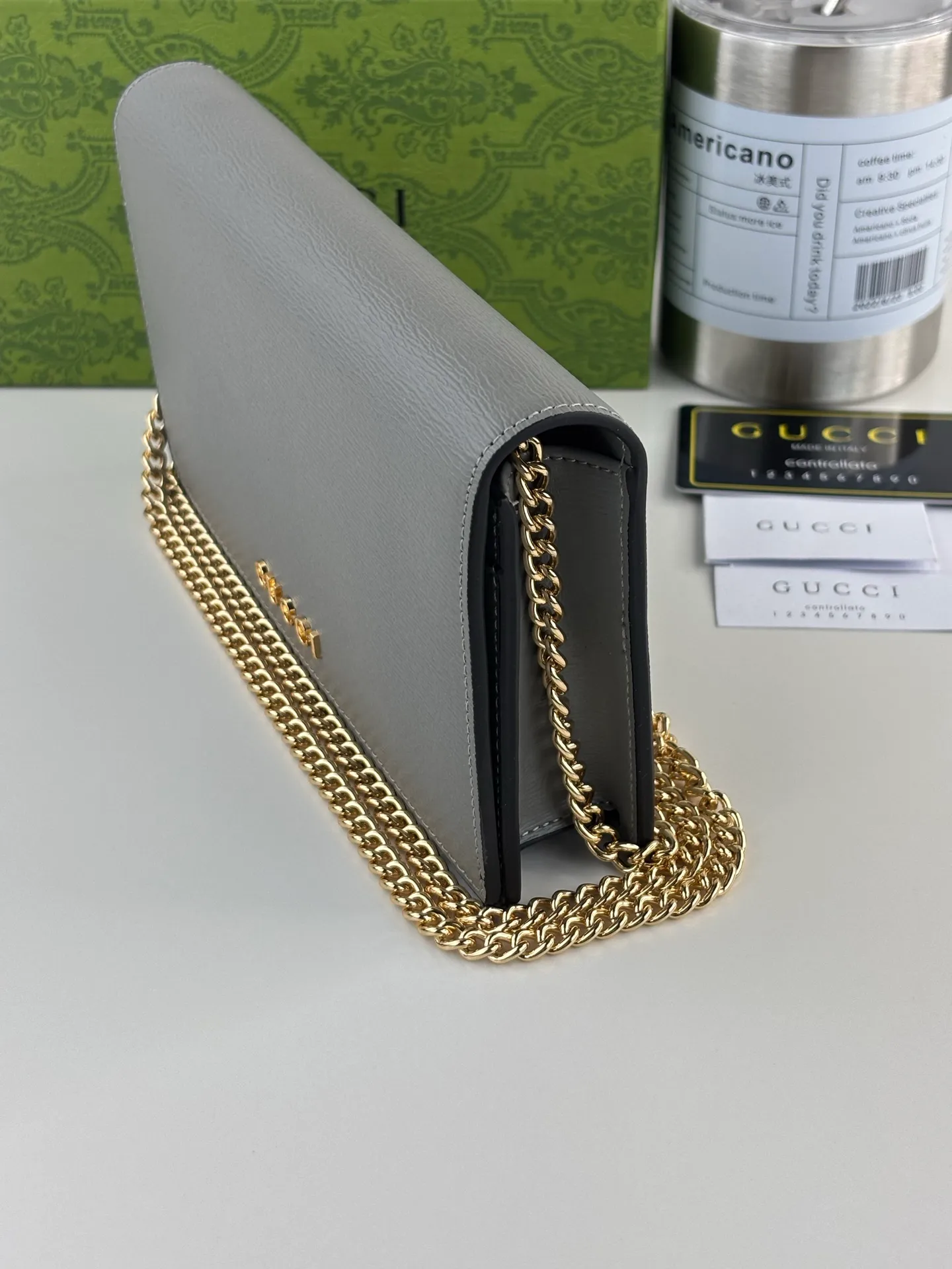 💰230 GUCCl chain wallet with handwritten Gucci logo. The small leather accessories series seamlessly integrates modern fashion elements to create ingenious items with changing styles without losing classic connotation, bringing fresh vitality to formal leather items. This chain wallet is crafted from gray leather and features the Gucci logo in gold-tone script. Gray leather, gold-tone hardware, taffeta lining, scripted Gucci logo detail, interior: six card compartments, one flat pocket, one zipped gusset pocket and one open compartment, chain strap, snap-stud fastening. Style number: 772643 Size: 20cm x 12.5cm x 4cm Color: Gray