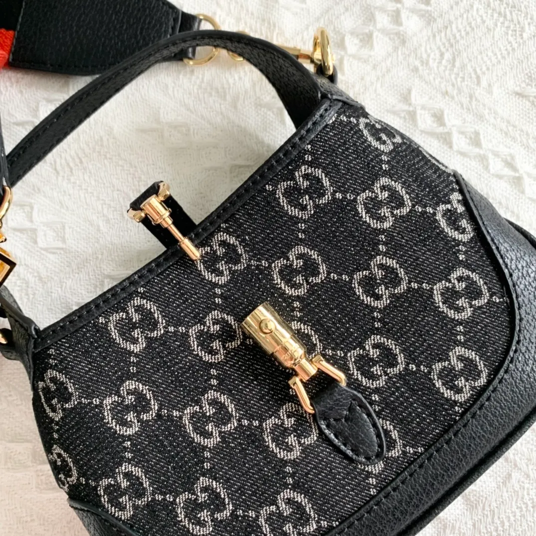 Actual shot #💰320 Model: 685127 black/Danny denim. Dimensions: 19 x 13x 3cm.  Gucci UN3AG 1294 product details. Gucci's "Aria-Fashion Aria" series uses modern techniques to reinterpret classics. The Jackie 1961 series has launched a new rectangular tote bag with soft texture and flexible structure. The archive design is paired with logo details such as the all-over GG pattern and striped webbing, and exquisite accessories pay tribute to Gucci's heritage. This small bag is trimmed in black leather and features the collection's signature gold-toned push-lock hardware. Black and ivory GG denim jacquard. Black leather trim.