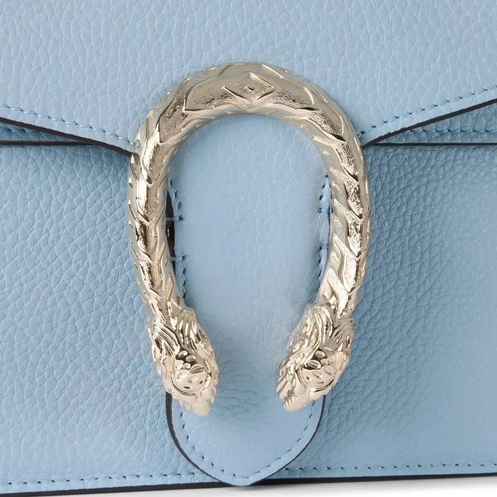 This piece is crafted from light blue leather and has a double tiger head lock with a flip design. The length can be adjusted freely by sliding the chain to create different styles. Light blue leather Light gold-tone hardware Light blue microfiber lining Pin buckle, side opening Double tiger head lock closure Internal zip compartment Flap pocket Double baffles Sliding chain shoulder strap can be adjusted to a shoulder strap with a height of 43 cm, or a top handle with a height of 24 cm. Weight: about 0.8 kg Model: 795005. Dimensions: 28cm (width) x 16cm (height) x 10.5cm (depth) Color: light blue full leather/original leather. Made in Italy