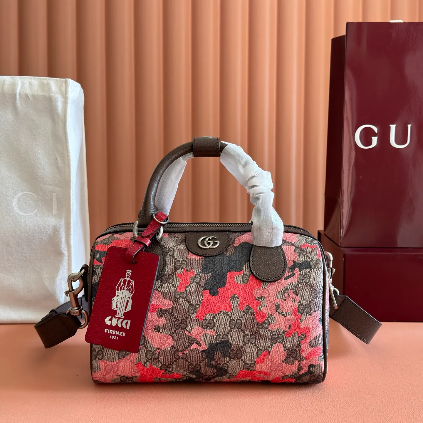 p1240💋💋💋【Original configuration counter complete package】Vivid camouflage combined with unique color matching, a new interpretation of the classic GG pattern. This travel bag is crafted from coated fabric with a marbled GG monogram pattern and features a matching ID plaque. Coated fabric with pink and red camouflage marbled GG monogram Brown, pink and red leather trim Palladium-toned hardware Unique cotton and linen lining Double G Interior: 1 zip pocket External: 1 removable bellman ID tag Handle height: 11 cm Removable and adjustable leather shoulder strap (height: 110 cm - 128 cm) Zip closure Ident No.: 854860. Dimensions: 25cm (width) x 16cm (height) x 14cm (depth) Weight: approx. 856g Color: camouflage pink/PVC.