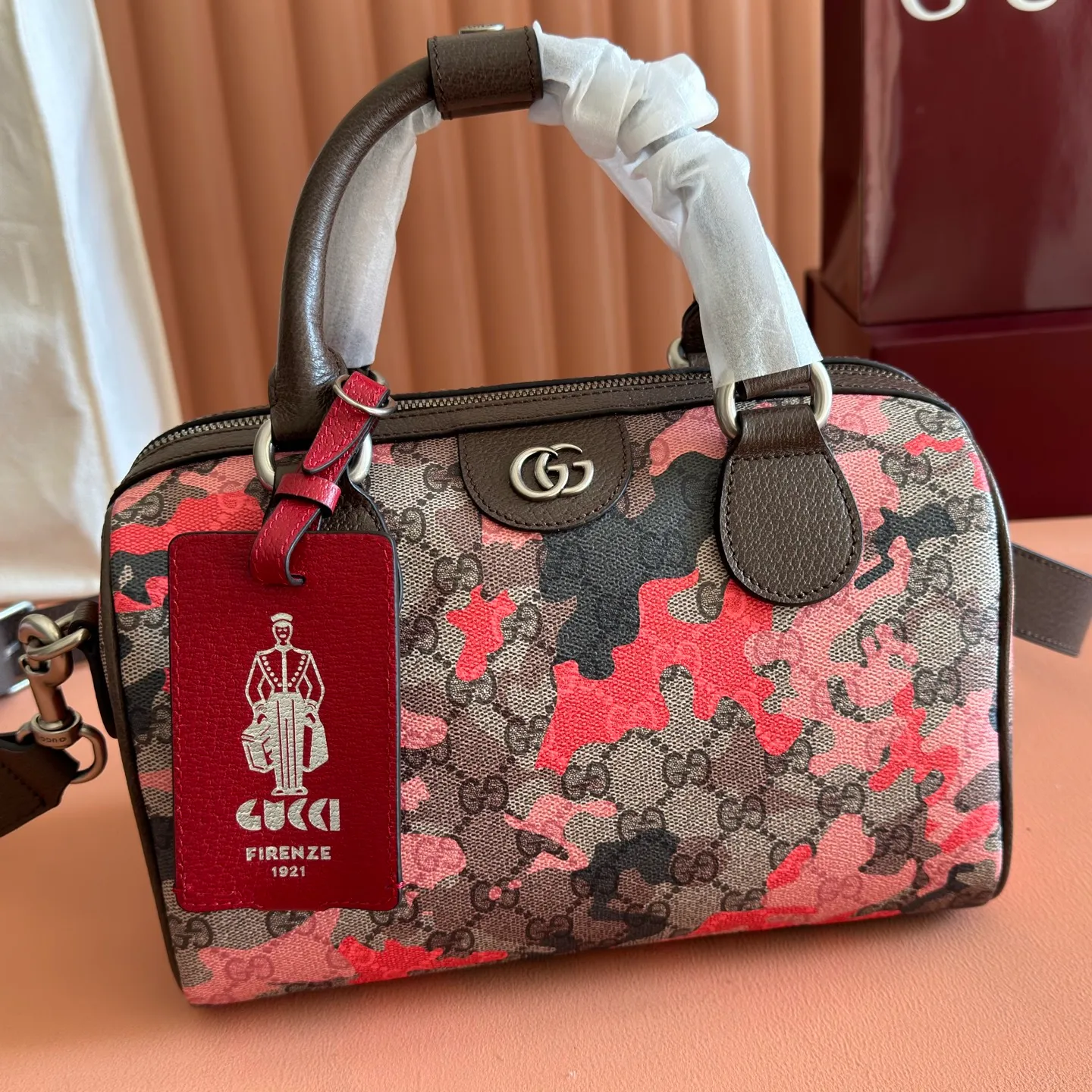 p1240💋💋💋【Original configuration counter complete package】Vivid camouflage combined with unique color matching, a new interpretation of the classic GG pattern. This travel bag is crafted from coated fabric with a marbled GG monogram pattern and features a matching ID plaque. Coated fabric with pink and red camouflage marbled GG monogram Brown, pink and red leather trim Palladium-toned hardware Unique cotton and linen lining Double G Interior: 1 zip pocket External: 1 removable bellman ID tag Handle height: 11 cm Removable and adjustable leather shoulder strap (height: 110 cm - 128 cm) Zip closure Ident No.: 854860. Dimensions: 25cm (width) x 16cm (height) x 14cm (depth) Weight: approx. 856g Color: camouflage pink/PVC.