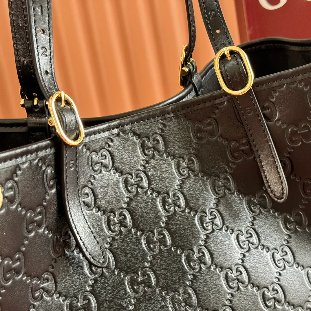 p1480. 💋💋💋Full set of original leather configuration counters [New Product] The new GG Emblem series reinterprets the brand's timeless elegance and exquisite craftsmanship. Inspired by the equestrian world, this tote bag features an adjustable top handle with numbered eyelets. Black Embossed Leather Black Microfiber Lining The bag pictured is sold separately and does not come with the bag charm. Also comes with D-ring for hanging removable items Adjustable handle with numbered eyelets; Height 21.5 cm - 31.5 cm Interior: 2 compartments and 1 central zipped compartment Magnetic snap closure Ident No.: 815213. Dimensions: 38cm (width) x 25cm (height) x 15cm (depth) Weight: approx. 0.85kg Color: black embossed/original leather. Made in Italy
