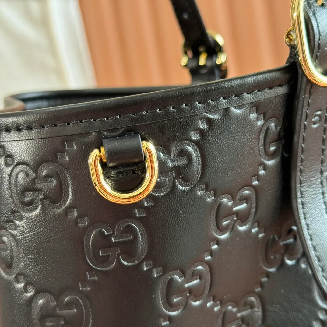 p1480. 💋💋💋Full set of original leather configuration counters [New Product] The new GG Emblem series reinterprets the brand's timeless elegance and exquisite craftsmanship. Inspired by the equestrian world, this tote bag features an adjustable top handle with numbered eyelets. Black Embossed Leather Black Microfiber Lining The bag pictured is sold separately and does not come with the bag charm. Also comes with D-ring for hanging removable items Adjustable handle with numbered eyelets; Height 21.5 cm - 31.5 cm Interior: 2 compartments and 1 central zipped compartment Magnetic snap closure Ident No.: 815213. Dimensions: 38cm (width) x 25cm (height) x 15cm (depth) Weight: approx. 0.85kg Color: black embossed/original leather. Made in Italy