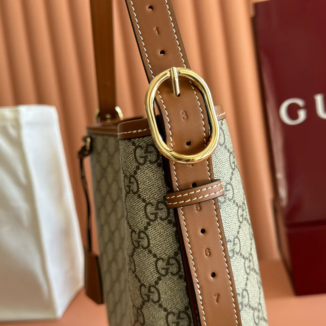 p1120. 💋💋💋【With full set of original counter packaging】💕The GG Emblem series reinterprets the brand's timeless elegance and exquisite craftsmanship. Lined in webbed cotton, this bucket bag features an internal compartment for added functionality. Beige and dark brown GG monogram coated fabric Brown leather trim Light gold tone hardware Webbing cotton lining Interior: Zip pocket Adjustable leather shoulder strap: Height: 26 cm - 47 cm; Length: 102 cm Magnetic closure Ident No.: 847452. Dimensions: 30.5cm (width) x 30.5cm (height) x 9cm (depth) Weight: approx. 0.85kg Color: Brown/PVC.