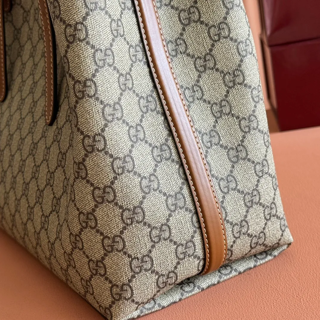 p980. 💋💋💋"With full set of original counter packaging" [New product] GG Emblem series reinterprets the brand's timeless elegance and exquisite craftsmanship. Inspired by the equestrian world, this tote bag features an adjustable top handle with numbered eyelets. New GG monogram coated fabric in beige and dark brown Orange leather trim with contrast stitching Light gold tone hardware Red and green webbing cotton lining The bag pictured is sold separately and does not come with the bag charm. Also features D-ring for hanging removable items Adjustable handle with numbered eyelets (height: 21.5 cm - 31.5 cm) Interior: two compartments and one central zipped compartment Magnetic snap closure Ident.: 815213. Dimensions: 38cm (width) x 25cm (height) x 15cm (depth) Weight: about 0.85kg Color: brown PVC/original leather. Made in Italy