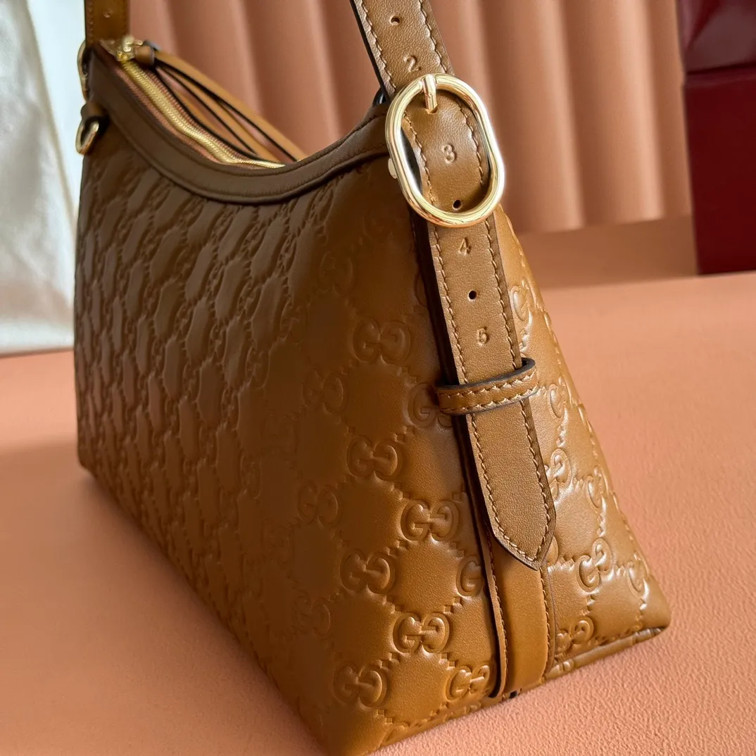 p1140. 💋💋💋"With full set of original counter packaging" [New Product] 2025 Autumn and Winter Series, the GG Emblem series reinterprets the brand's timeless elegance and exquisite craftsmanship. This shoulder bag is crafted from GG embossed leather, showing off its exquisite texture. Gucci Rosso Ancora GG printed embossed leather Light gold tone accessories Gucci Rosso Ancora cotton lining The bag pictured is sold separately and does not come with the bag charm. Interior: Zippered pocket Adjustable leather shoulder strap: Height: 16 cm - 26 cm; Length: 72 cm Zipper closure Ident: 847449. Dimensions: 30cm (W) x 19cm (H) x 11cm (D) Weight: Approx. 0.45kg Color: Brown embossed. Made in Italy