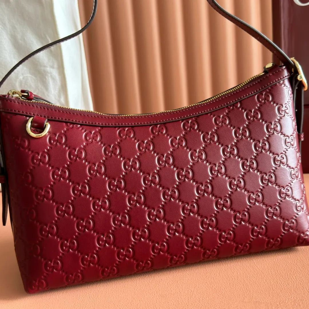 p1140. 💋💋💋"With full set of original counter packaging" [New Product] 2025 Autumn and Winter Series, the GG Emblem series reinterprets the brand's timeless elegance and exquisite craftsmanship. This shoulder bag is crafted from GG embossed leather, showing off its exquisite texture. Gucci Rosso Ancora GG printed embossed leather Light gold tone accessories Gucci Rosso Ancora cotton lining The bag pictured is sold separately and does not come with the bag charm. Interior: Zippered pocket Adjustable leather shoulder strap: Height: 16 cm - 26 cm; Length: 72 cm Zipper closure Ident: 847449. Dimensions: 30cm (W) x 19cm (H) x 11cm (D) Weight: Approx. 0.45kg Color: Anchor Red embossed. Made in Italy