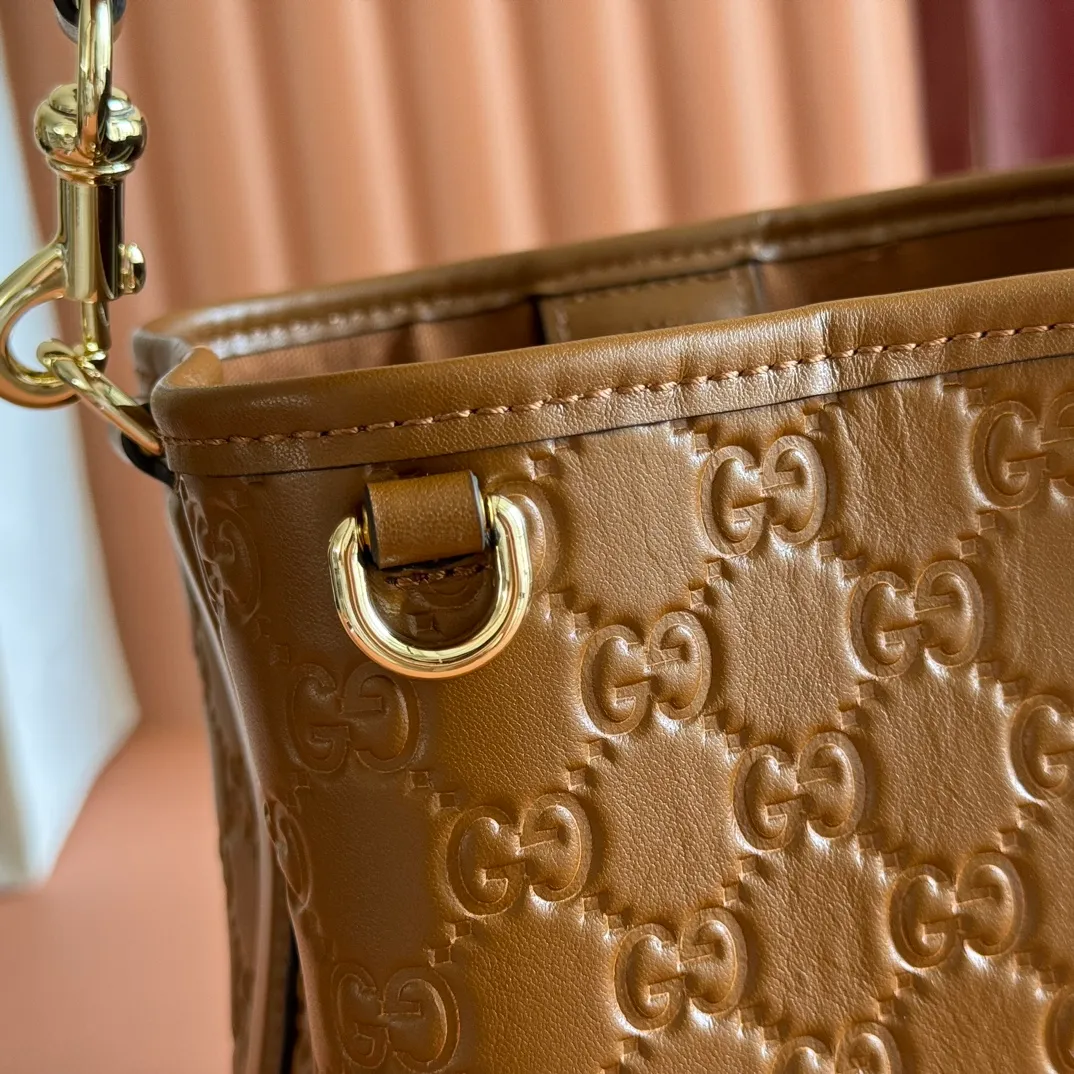 p1140. 💋💋💋 Comes with a full set of original counter packaging [New Product] 2025 Autumn and Winter Series, the GG Emblem series reinterprets the brand's timeless elegance and exquisite craftsmanship. Lined in tonal cotton, this practical bucket bag features an internal compartment. Anchor red printed embossed GG calf leather Light gold-toned lining Anchor red cotton lining Top handle with hook closure (height: 14 cm) Additional D-ring for attaching detachable items Interior: two compartments and a central snap-stud compartment Removable and adjustable calfskin leather shoulder strap (height: 52 cm - 57.5 cm; length: 107 cm - 114 cm) Magnetic snap closure Ident No.: 815118. Dimensions: 19cm (W) x 18cm (H) x 11cm (D) Weight: Approx. 0.45kg Color: Anchor red embossed. Made in Italy