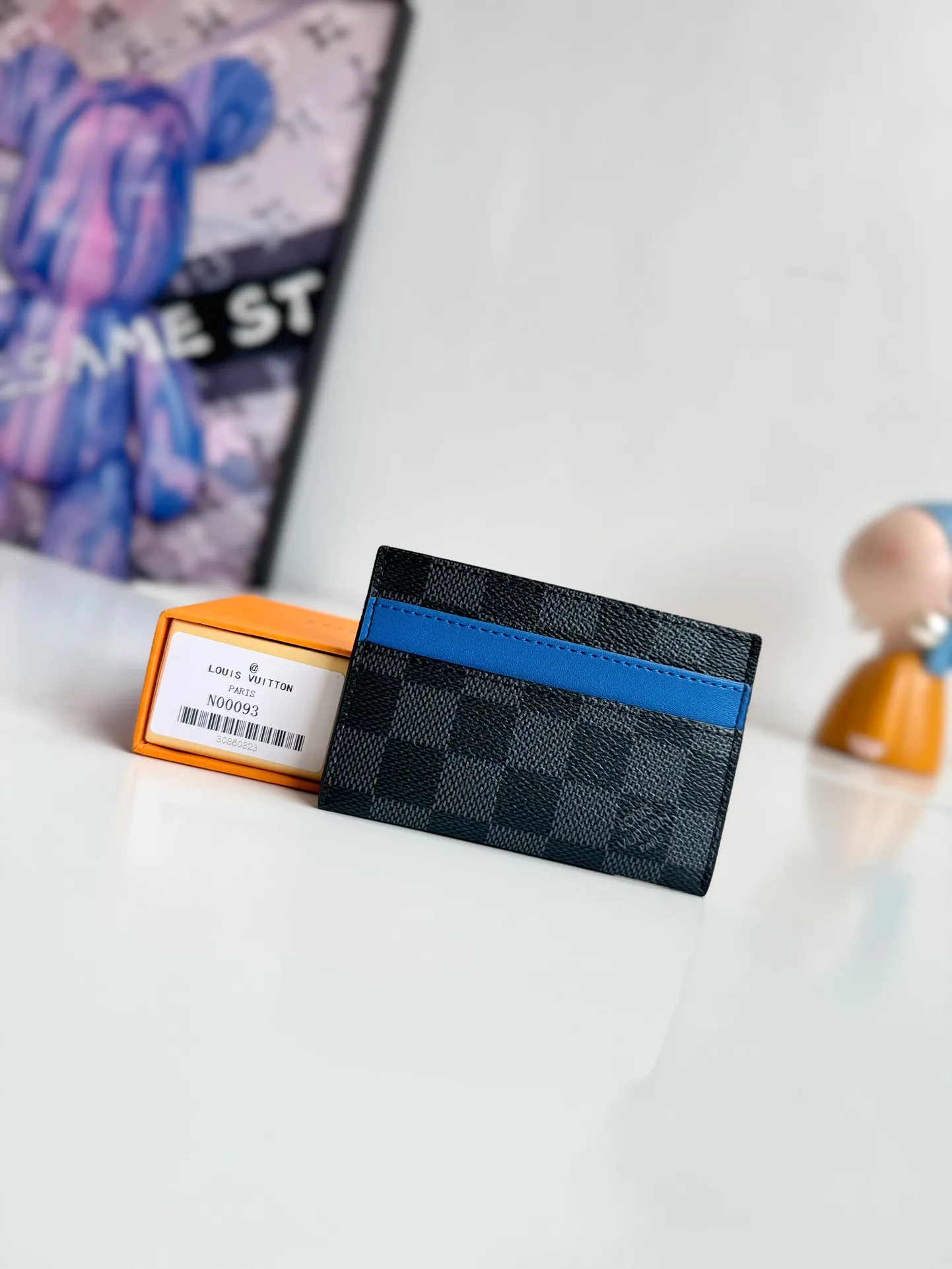 P260🇫🇷Exclusive real shot of overseas original order N00093! A ring of blue cowhide leather at the top of this double card holder in Damier Graphite coated canvas adds a fresh touch to Damier's gray checkerboard. It includes four card slots on the exterior and a central pocket, also lined in blue leather, for storing tickets or other small items. Size: 11×7×1.5cm