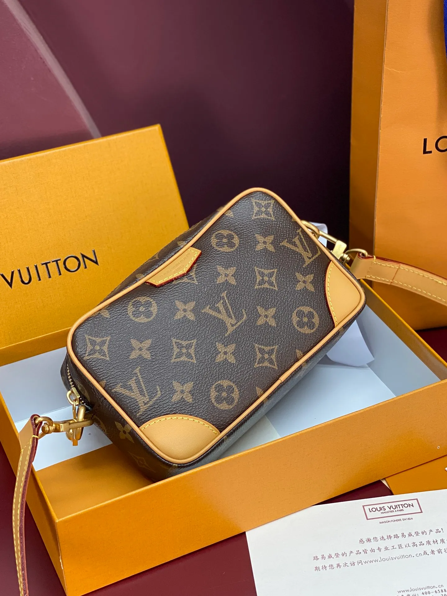 M14058 Presbyopia! Chip version! TROCADÉRO MINI BAG! This Trocadéro mini bag is crafted in Monogram Heritage coated canvas with leather trim and trunk-style reinforced corners, a nod to the brand's compact crossbody designs created in the 1980s. Classic tones complement the colorful striped lining, and the detachable and adjustable shoulder strap allows for shoulder or cross-body wear.  Dimensions 13 x 6.5 x 20 cm.