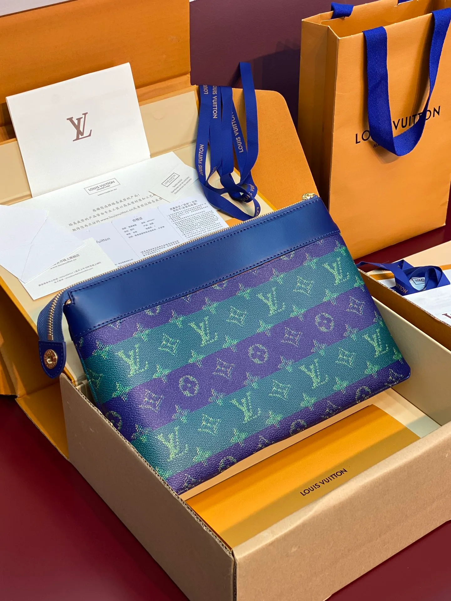 Upgraded version ⚠️M11545 blue stripe! POCHETTE VOYAGE SOUPLE Clutch The Pochette Voyage Souple Clutch is made of soft Monogram Eclipse coated canvas, and uses rounded strokes to outline the classic Pochette Voyage Clutch lines, bringing a comfortable travel experience. The slim construction features a zip compartment and magnetic back pocket. 32 x 21 x 8 cm (length x height x width). 💰700