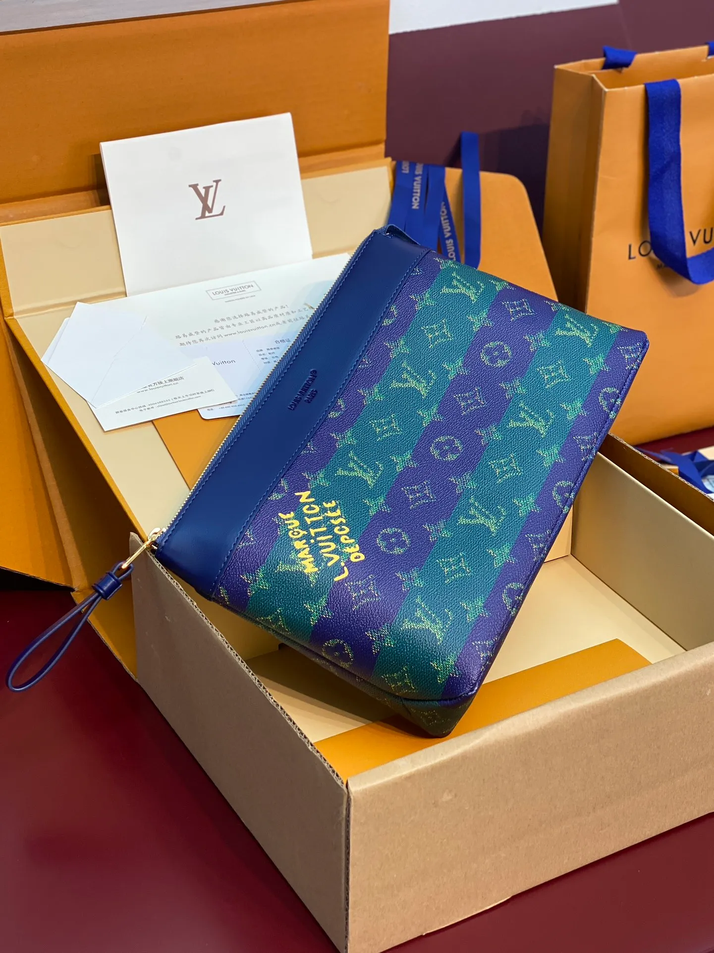 Upgraded version ⚠️M11545 blue stripe! POCHETTE VOYAGE SOUPLE Clutch The Pochette Voyage Souple Clutch is made of soft Monogram Eclipse coated canvas, and uses rounded strokes to outline the classic Pochette Voyage Clutch lines, bringing a comfortable travel experience. The slim construction features a zip compartment and magnetic back pocket. 32 x 21 x 8 cm (length x height x width). 💰700