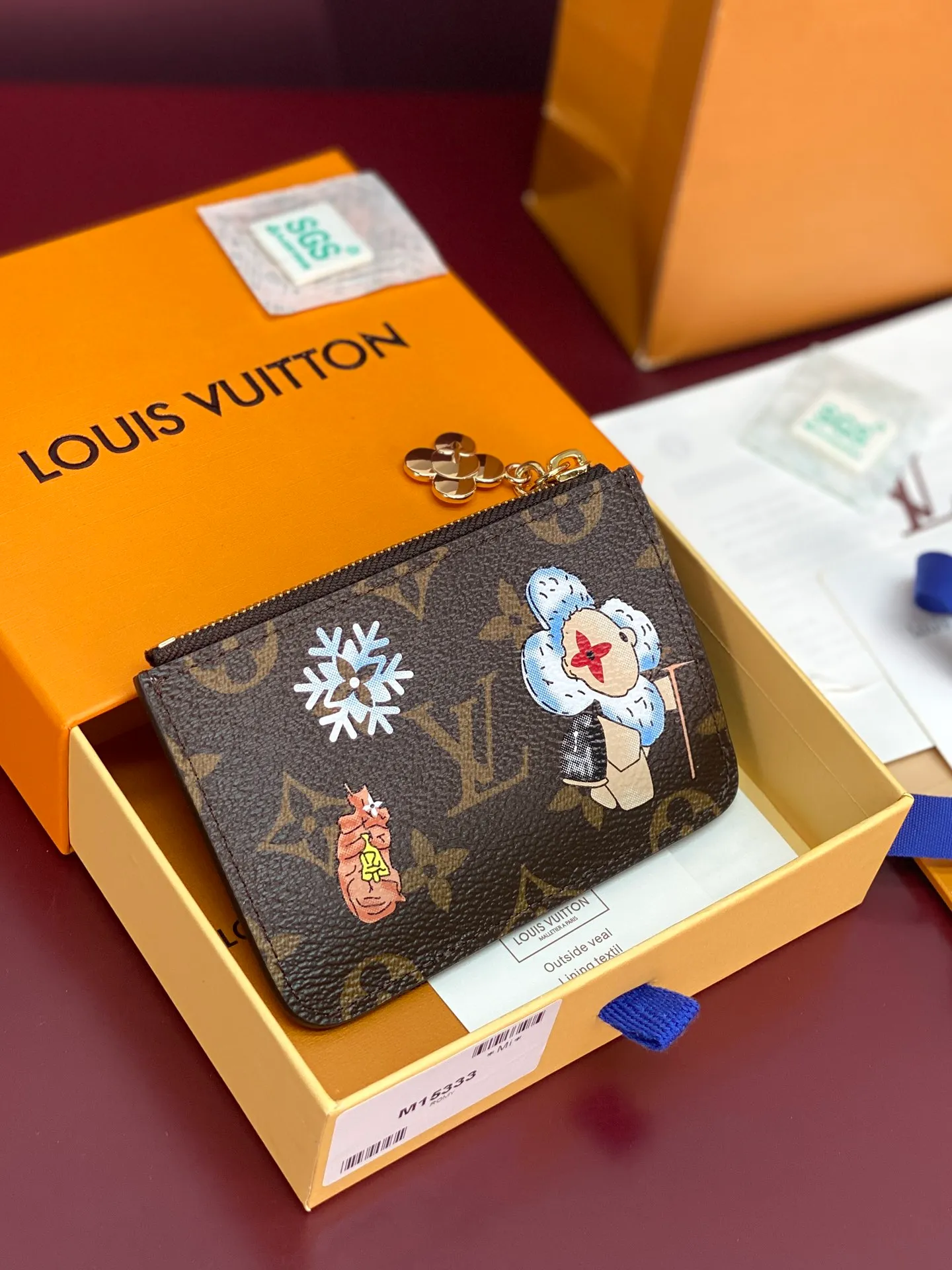 M15333 Christmas model! (High Quality⚠️) ROMY Card Holder, this Romy card holder is a fun new take on the Vivenne Wintery Travel series. Made of Monogram canvas and lined with leather, it features a zip pull featuring Vivienne, the brand's mascot, card slots, a zipped coin pocket and a bill patch pocket.  8 x 0.8 x 12 cm (height x width x length). 💰380