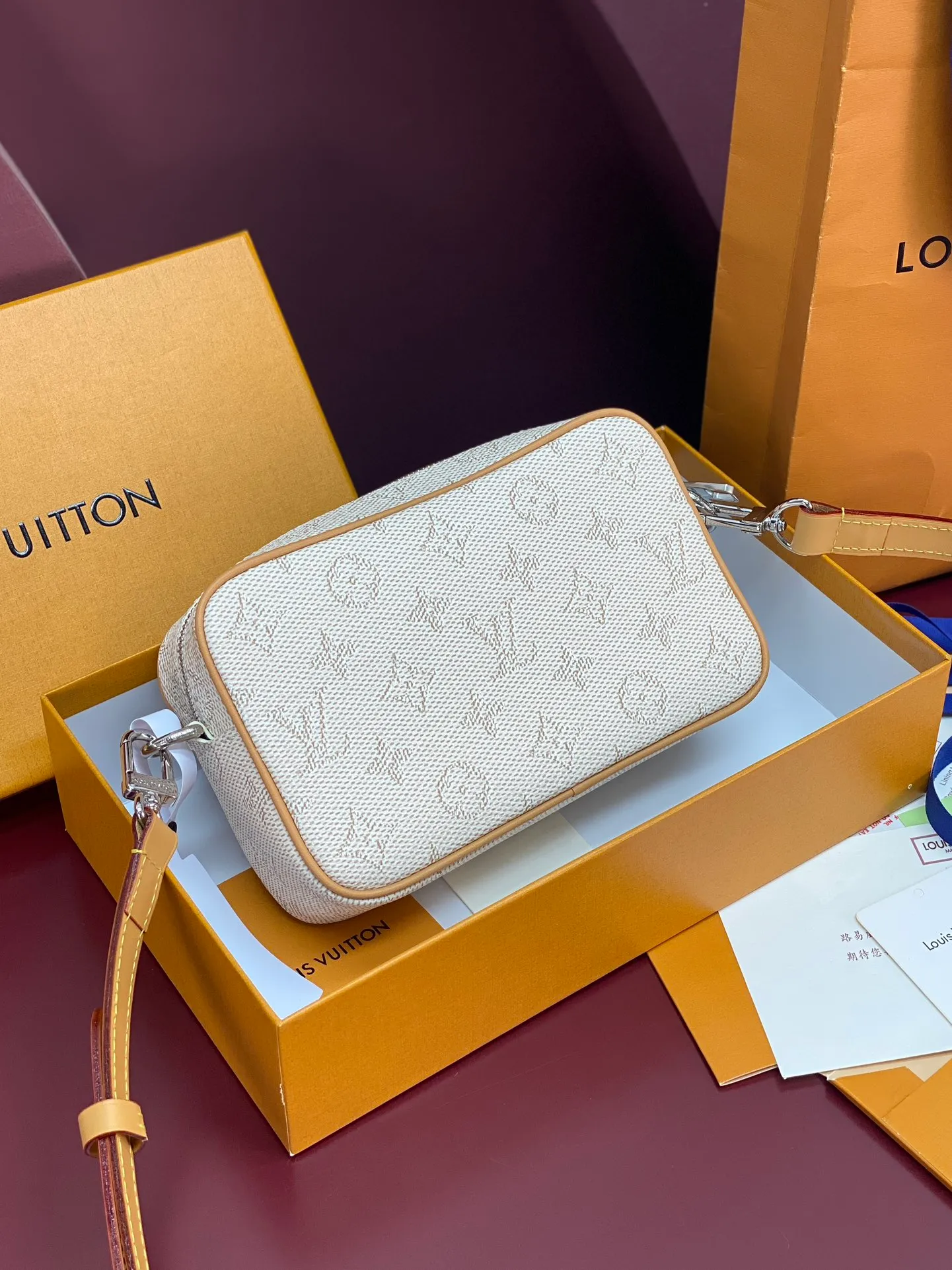 M27155 silk screen apricot color! Chip version! TROCADÉRO MINI BAG! This Trocadéro mini bag is crafted in Monogram Heritage coated canvas with leather trim and trunk-style reinforced corners, a nod to the brand's compact crossbody designs created in the 1980s. The apricot tone complements the colorful striped lining, and the detachable and adjustable shoulder strap allows for shoulder or cross-body wear.  Dimensions 13 x 6.5 x 20 cm.
