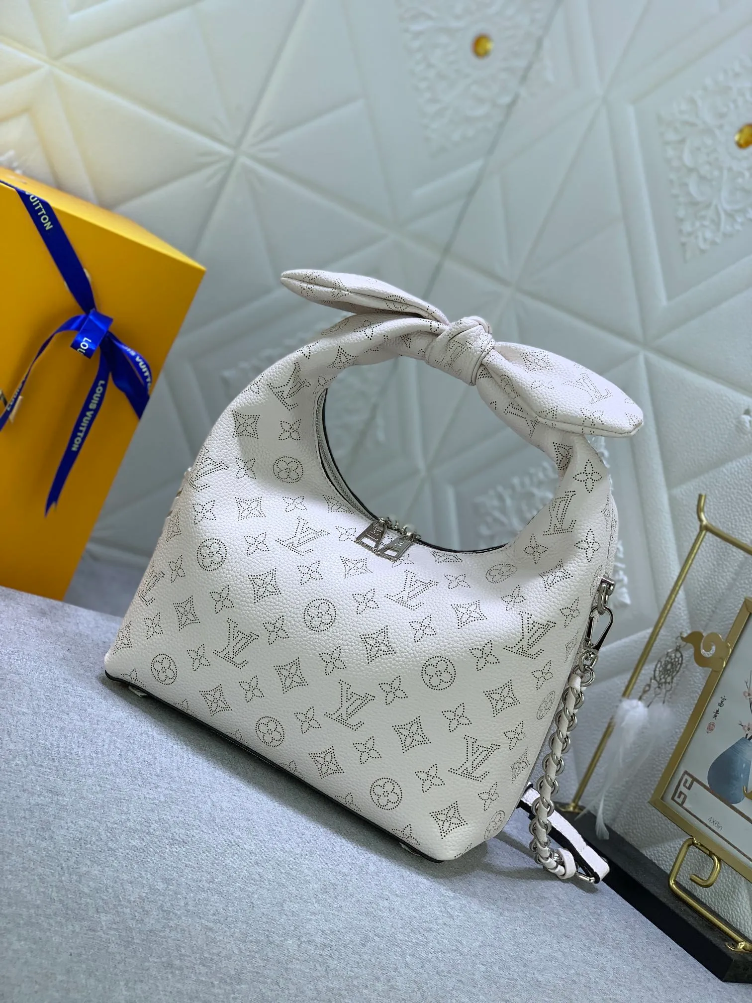 All categories Official website "Brand Women's Bags" Women's Bags 💙 LV Why Knot small handbag is made of Louis Vuitton's iconic Monogram engraved and perforated cow leather, combined with a knot-shaped handle, exuding a gentle style and modern atmosphere. Functional design holds everyday essentials such as a cell phone, wallet, keys, and sunglasses, and the removable woven leather chain allows for easy shoulder wear.