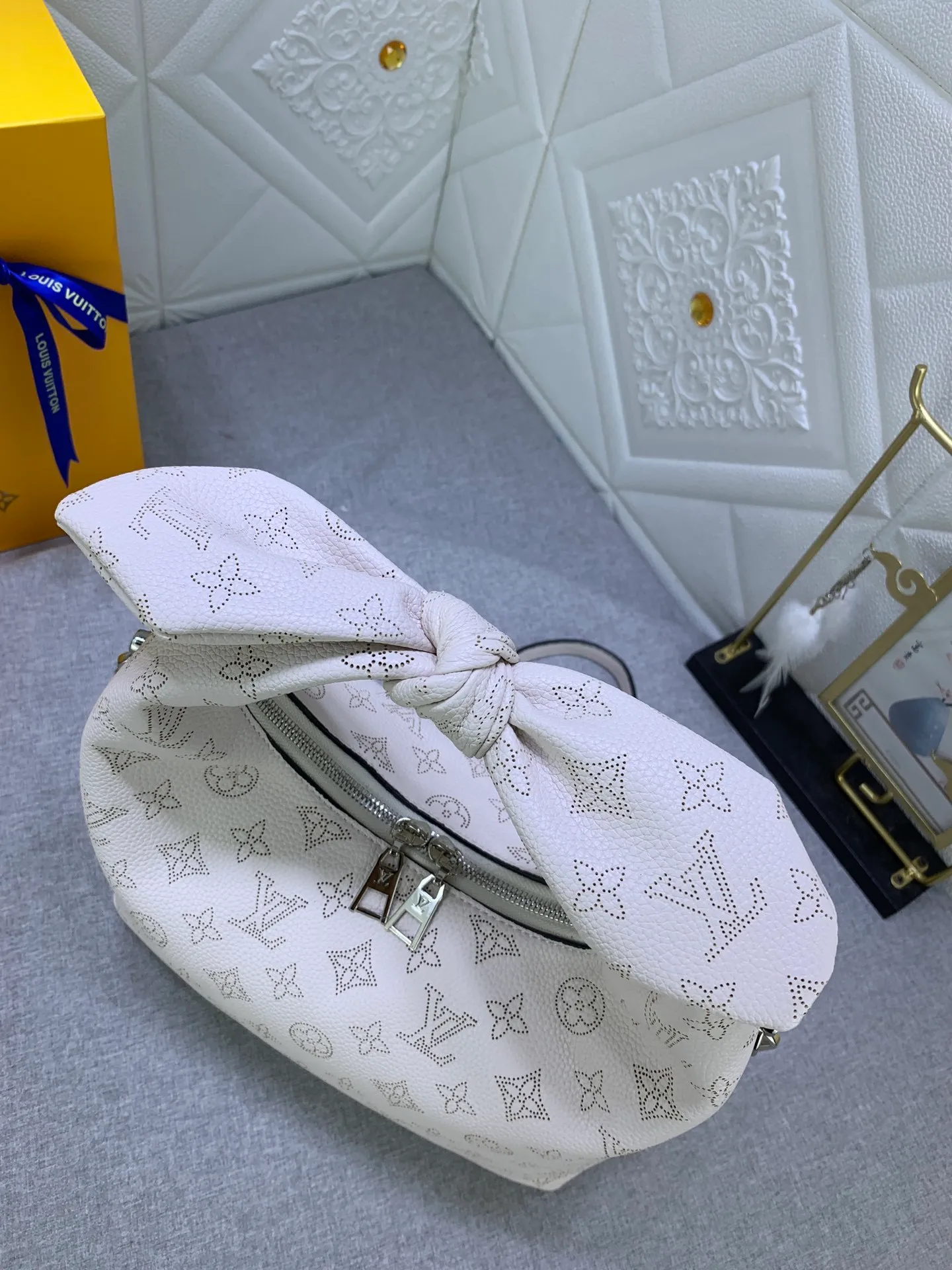 All categories Official website "Brand Women's Bags" Women's Bags 💙 LV Why Knot small handbag is made of Louis Vuitton's iconic Monogram engraved and perforated cow leather, combined with a knot-shaped handle, exuding a gentle style and modern atmosphere. Functional design holds everyday essentials such as a cell phone, wallet, keys, and sunglasses, and the removable woven leather chain allows for easy shoulder wear.