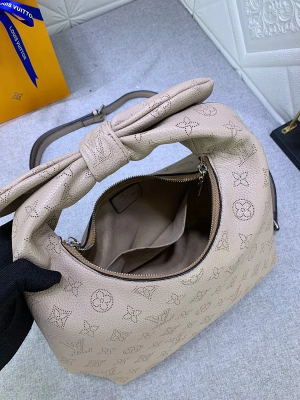 All categories Official website "Brand Women's Bags" Women's Bags 💙 LV Why Knot small handbag is made of Louis Vuitton's iconic Monogram engraved and perforated cow leather, combined with a knot-shaped handle, exuding a gentle style and modern atmosphere. Functional design holds everyday essentials such as a cell phone, wallet, keys, and sunglasses, and the removable woven leather chain allows for easy shoulder wear.