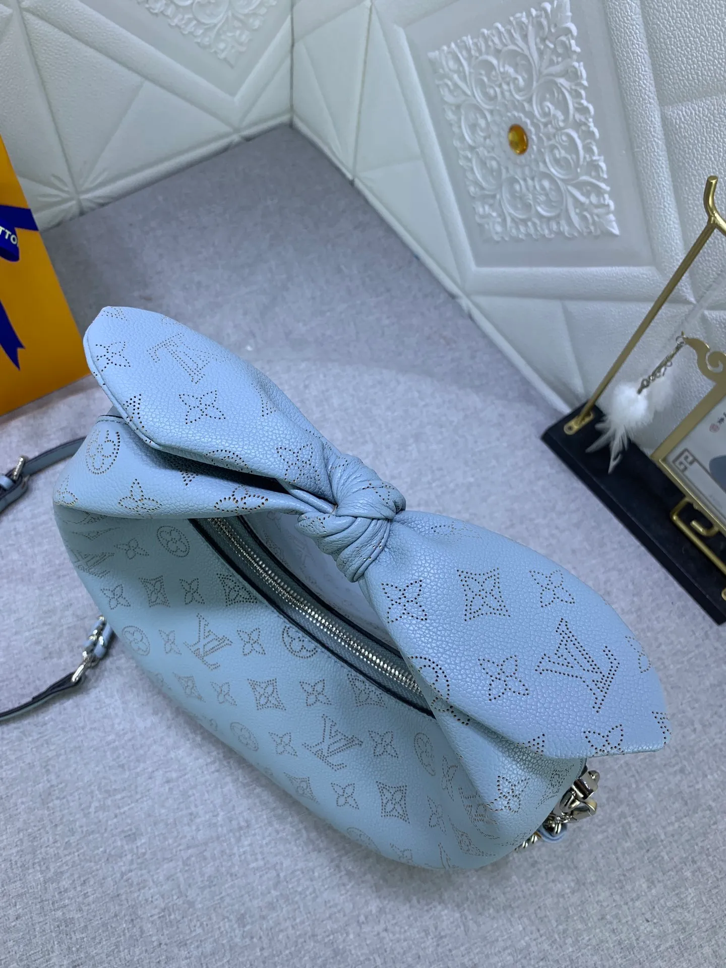 All categories Official website "Brand Women's Bags" Women's Bags 💙 LV Why Knot small handbag is made of Louis Vuitton's iconic Monogram engraved and perforated cow leather, combined with a knot-shaped handle, exuding a gentle style and modern atmosphere. Functional design holds everyday essentials such as a cell phone, wallet, keys, and sunglasses, and the removable woven leather chain allows for easy shoulder wear.
