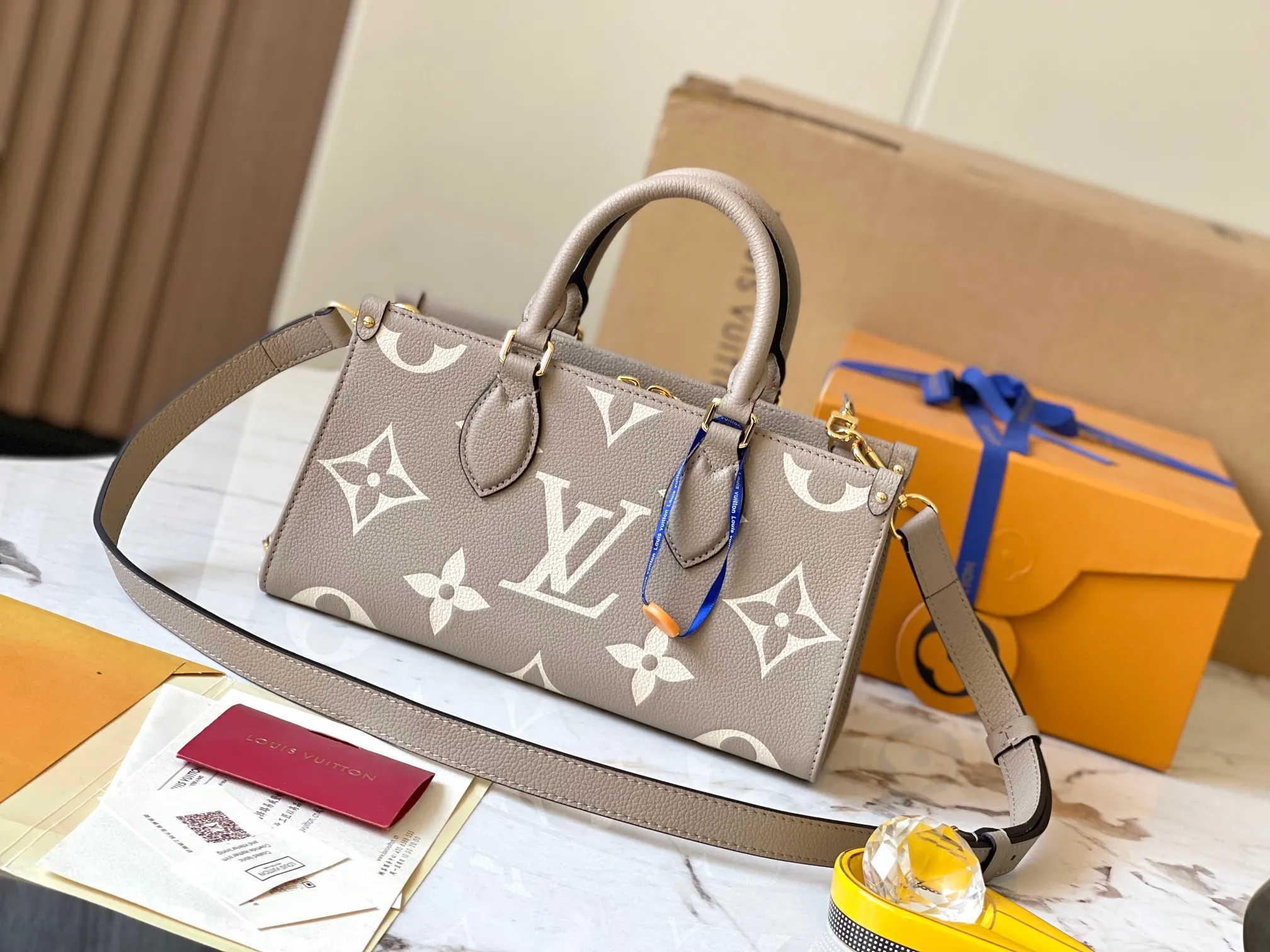 p1440 [Original leather, 💋 M23641 elephant gray] This OnTheGo small handbag is made of Monogram Empreinte leather with a Giant Monogram pattern embossed on it, highlighting its soft and slender silhouette. The compact interior keeps your daily essentials organized, while the articulated top handle and detachable leather and woven chain shoulder strap allow for a variety of carrying options. 25 x 13 x 10 cm (length x height x width)