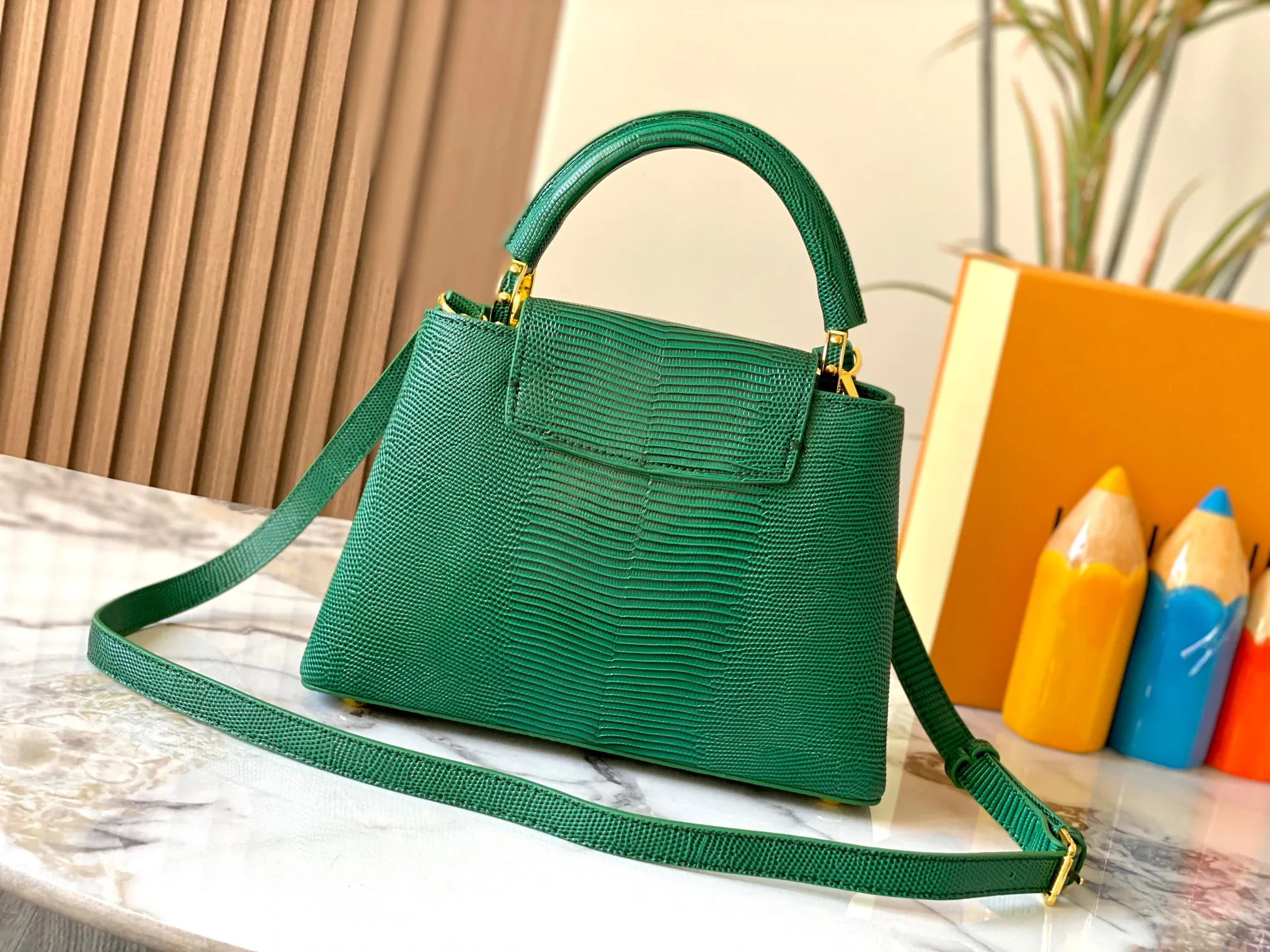 Top original P440 Guangzhou-made M99528 green lizard skin gold buckle CapucinesBB handbag exquisitely combines graceful lizard skin outer layer, delicate sheepskin lining and glossy metal parts. The iconic flap makes two styles fashionable. The LV logo can be read on the inside and Monogram flowers bloom on the outside. It can light up an eye-catching corner for evening occasions and add a personalized atmosphere to the wardrobe. Shine gorgeous style in day and night occasions.  Detailed features 27 x 18 x 9 cm (length x height x width)