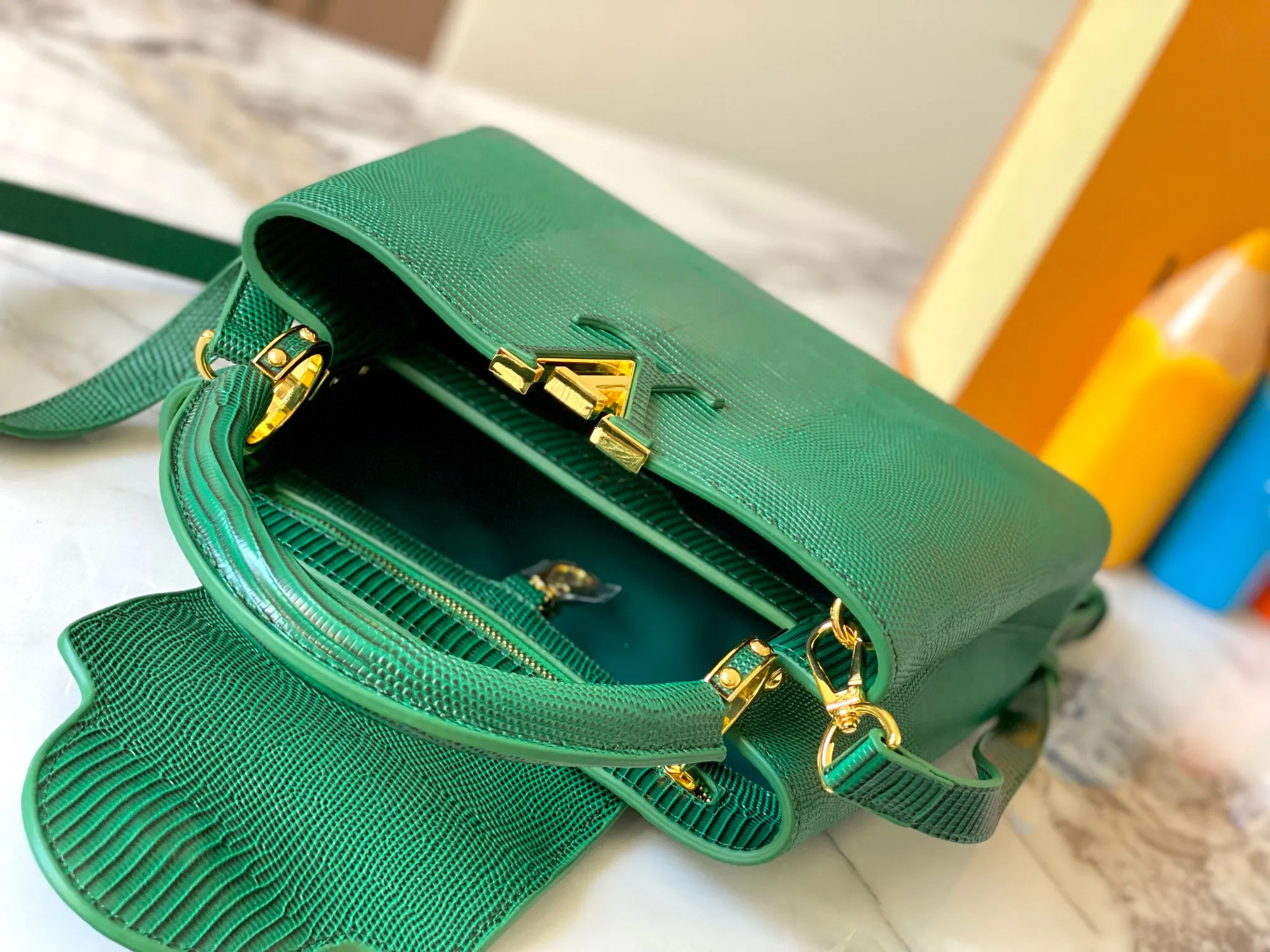 Top original P440 Guangzhou-made M99528 green lizard skin gold buckle CapucinesBB handbag exquisitely combines graceful lizard skin outer layer, delicate sheepskin lining and glossy metal parts. The iconic flap makes two styles fashionable. The LV logo can be read on the inside and Monogram flowers bloom on the outside. It can light up an eye-catching corner for evening occasions and add a personalized atmosphere to the wardrobe. Shine gorgeous style in day and night occasions.  Detailed features 27 x 18 x 9 cm (length x height x width)