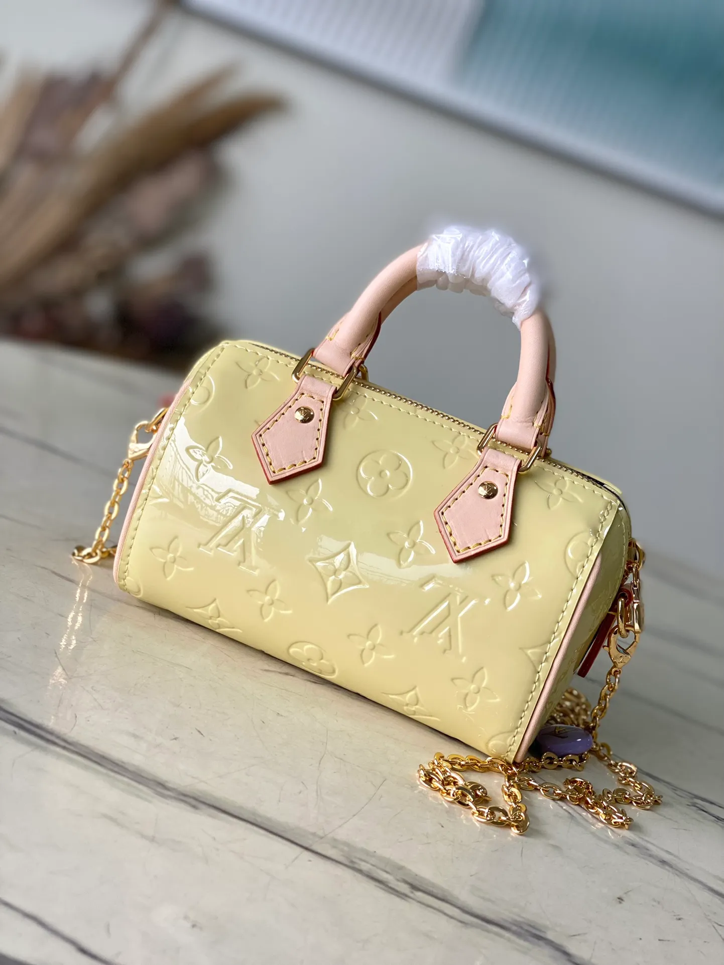 💰1020 (top layer leather) top original order M83000 yellow. This Nano Speedy handbag is made of Monogram Vernis pastel patent leather. It is a mini version of the brand's most famous travel bag. The bright patent leather is embossed with the Monogram pattern and features a natural leather top handle. The detachable gold chain strap is embellished with a charm and is the perfect size for mobile phones and small wallets. Dimensions: 16 x 10 x 7.5 cm (length x height x width)
