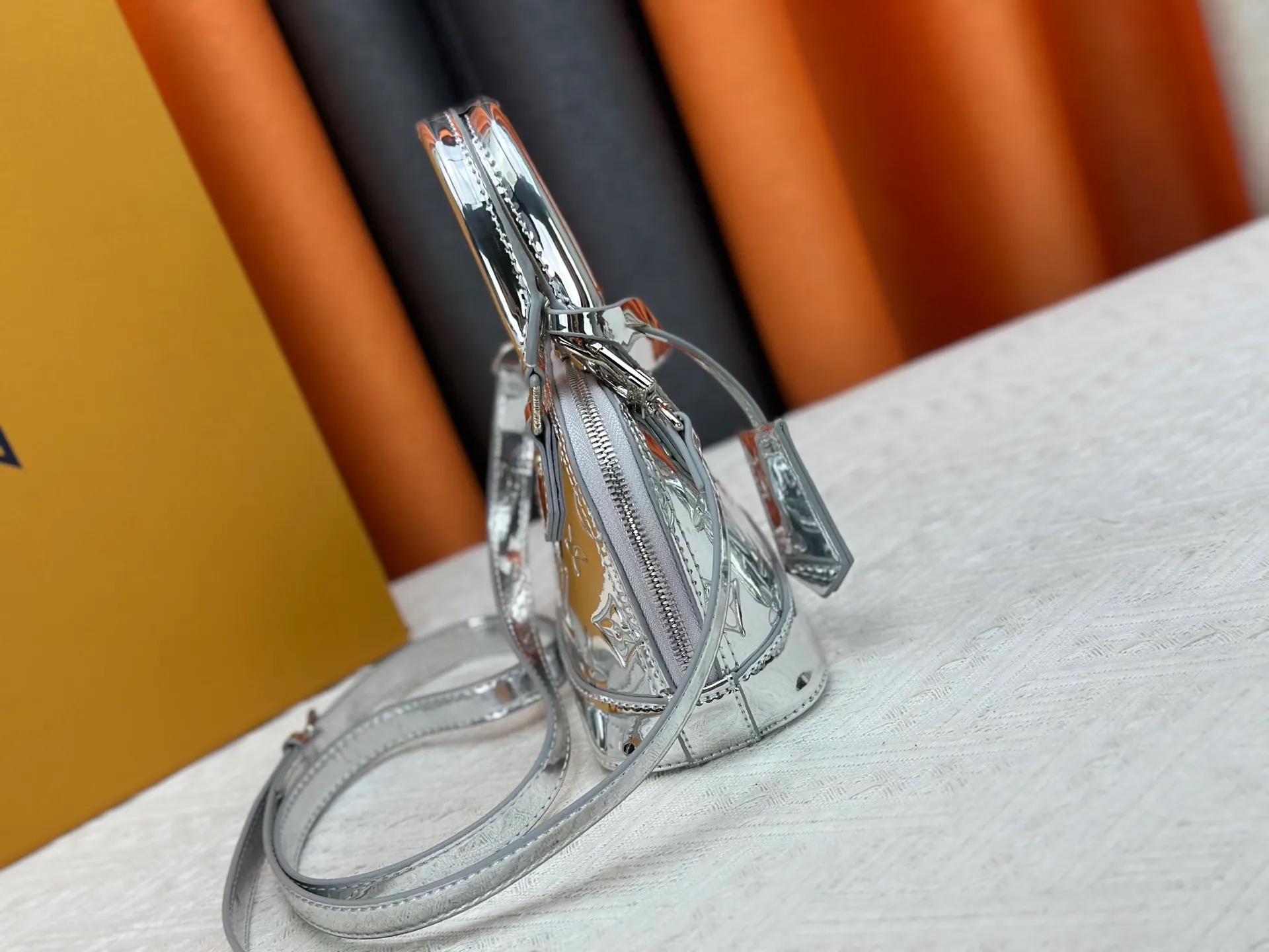 P280 M11835 M53152 82717 90611 The Alma mini handbag of the LVSki series draws inspiration from the Louis Vuitton archive hard box, rendering a new Monogram Miroir effect on the Monogram embossed coated canvas, highlighting the concept of retro futurism. Spacious interior patch pockets ensure organized storage. Size: 18x12x8cm
