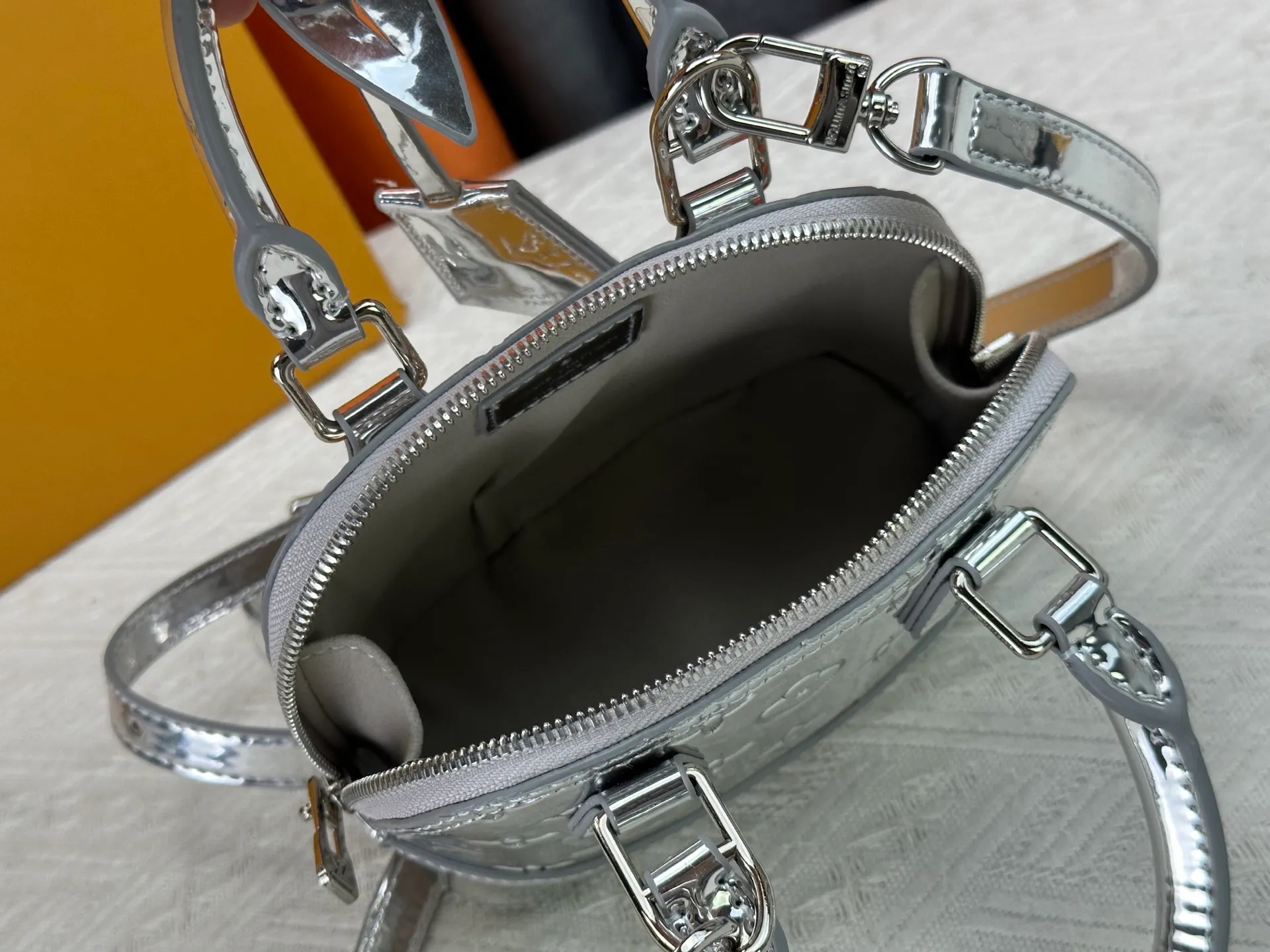 P280 M11835 M53152 82717 90611 The Alma mini handbag of the LVSki series draws inspiration from the Louis Vuitton archive hard box, rendering a new Monogram Miroir effect on the Monogram embossed coated canvas, highlighting the concept of retro futurism. Spacious interior patch pockets ensure organized storage. Size: 18x12x8cm