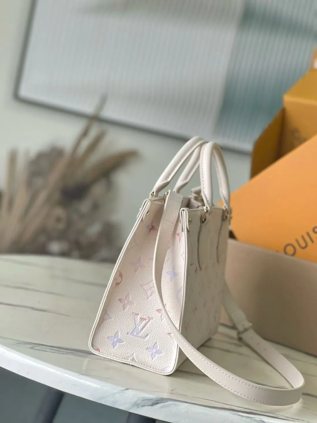 💰980 (top layer leather) top original order M25770 This small OnTheGo handbag comes from the Dream series and lights up various looks with its elegant design. Monogram Empreinte leather is combined with digital printing technology to cleverly present a gradient watercolor effect. The dazzling metal parts and multiple pockets are rich in details. The slender shoulder strap is convenient for cross-body wear. Dimensions: 25 × 19 × 11.5 cm