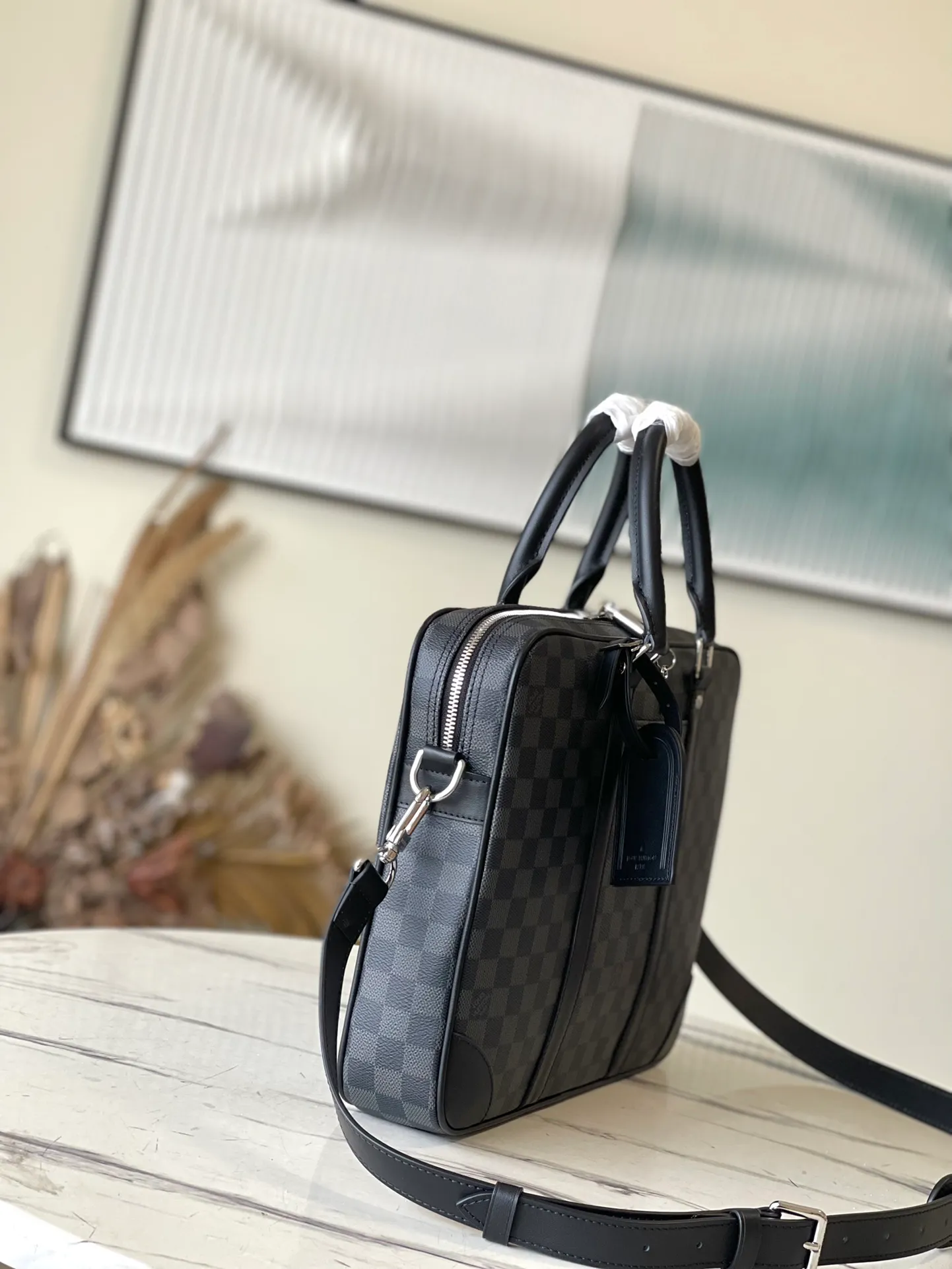 💰1000 Top Original N40445 This Voyage small briefcase is made of Damier Graphite coated canvas, with leather side straps, reinforced corners, top handles and nameplate. The outer pocket makes it easy to store a smartphone, the padded interior compartment holds a 13-inch laptop, and the removable and adjustable shoulder strap makes it comfortable to carry over the shoulder. Dimensions: 36.5 x 27.5 x 6 cm