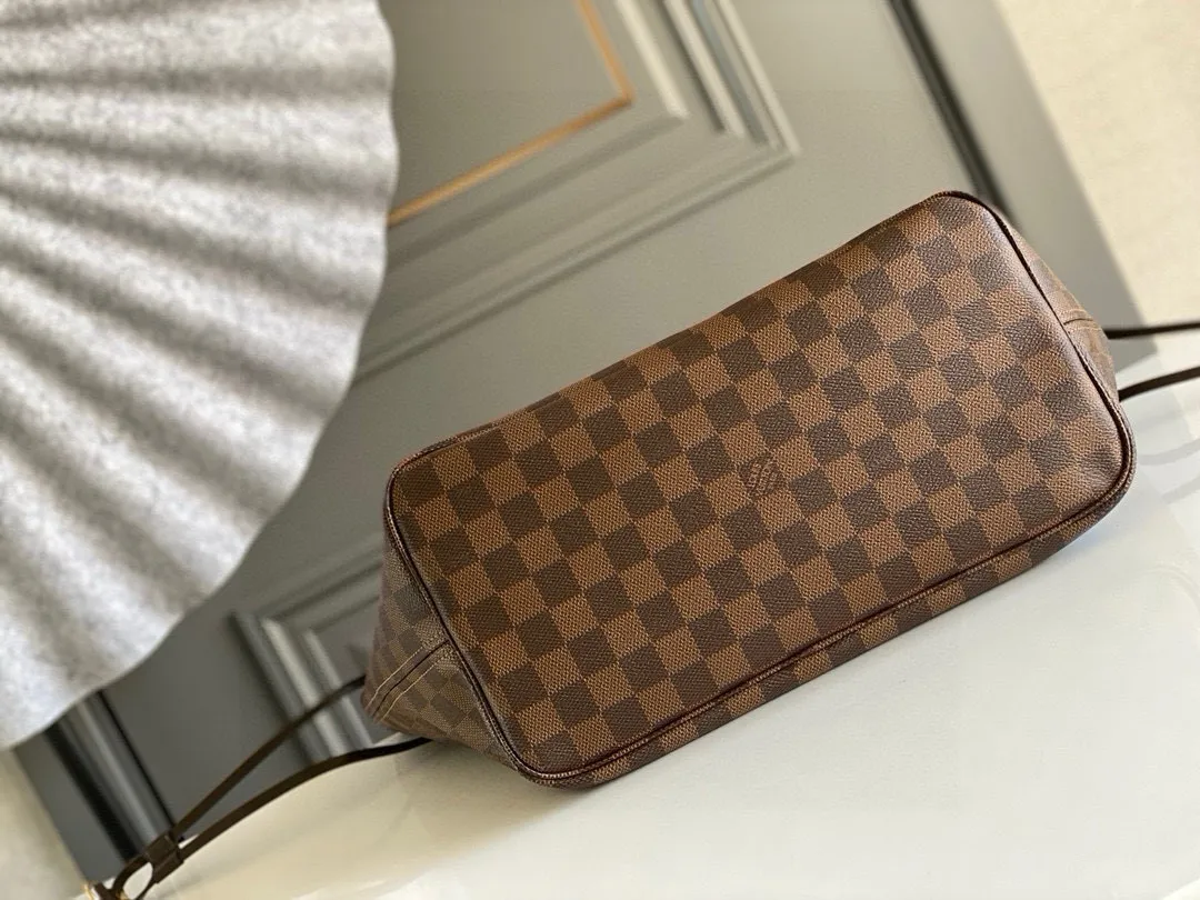 💰760 (Medium Steel Nail) Top Original N41358 NEVERFULL Medium Handbag The legendary Neverfull handbag can always meet your various needs for handbags. It has a large capacity but is not bulky. It is stiff and soft to the touch, making it suitable for home and travel. Tighten the side ties and it instantly transforms into a stylish urban handbag. Loosen the straps and it transforms into a chic and practical handbag. The slender leather handle can be carried over the shoulder or between the arms. The model shown here is made of Damier Ebène canvas.  Detailed Features 31 x 28 x 14 cm (Length x Height x Width) Bag interior redesigned with vintage details inspired by the Louis Vuitton archives - Fabric-lined interior pocket Removable zip clutch with matching interior Natural cowhide leather trim Shiny gold-tone brass hardware Handles: Double handle