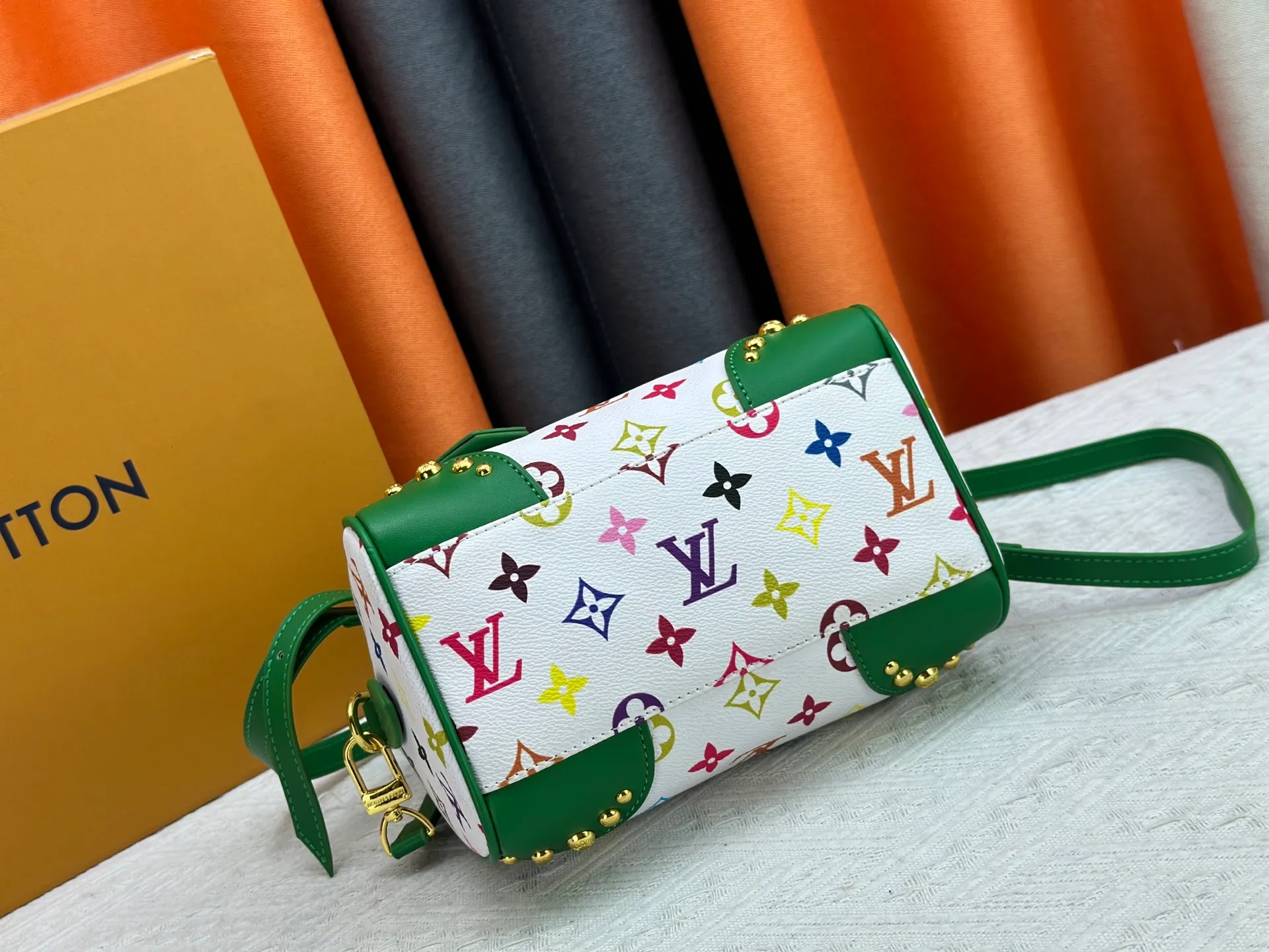 P260 upgraded original M58953 M46234 M46222 Speedy Bandoulière 20 handbag is made of soft coated canvas, and the full-length Monogram pattern is traced in colorful rainbow tones, highlighting the smart style of the Louis Vuitton x Murakami reissue series. The Toron handle and detachable shoulder strap are constructed of cow leather, the metal corners recall classic luggage elements, and the bow-shaped key bag and padlock add brand touches. Dimensions: 20.5 x 13.5 x 12.0 cm (length x height x width)