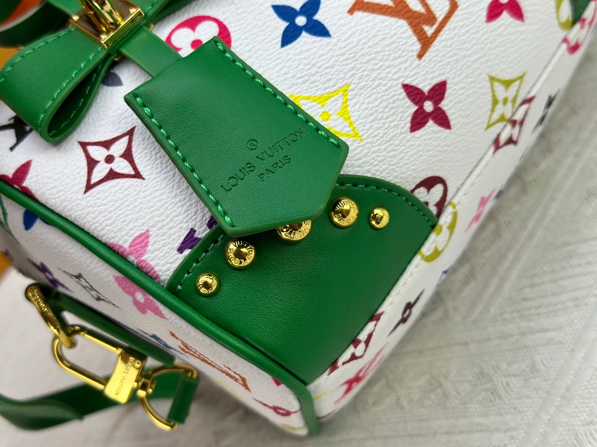 P260 upgraded original M58953 M46234 M46222 Speedy Bandoulière 20 handbag is made of soft coated canvas, and the full-length Monogram pattern is traced in colorful rainbow tones, highlighting the smart style of the Louis Vuitton x Murakami reissue series. The Toron handle and detachable shoulder strap are constructed of cow leather, the metal corners recall classic luggage elements, and the bow-shaped key bag and padlock add brand touches. Dimensions: 20.5 x 13.5 x 12.0 cm (length x height x width)