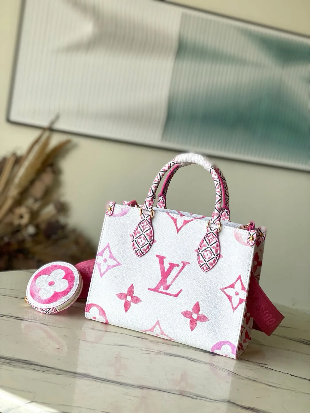 💰960 Top Original M22976 Pink This OnTheGo small handbag is made of canvas with a light Giant Monogram pattern, and detailed Monogram flowers are traced on the trim and top handle, showing the inspiration of traditional Portuguese tiles. Removable and adjustable shoulder strap for comfortable shoulder carrying experience. Dimensions: 25 x 19 x 11.5 cm