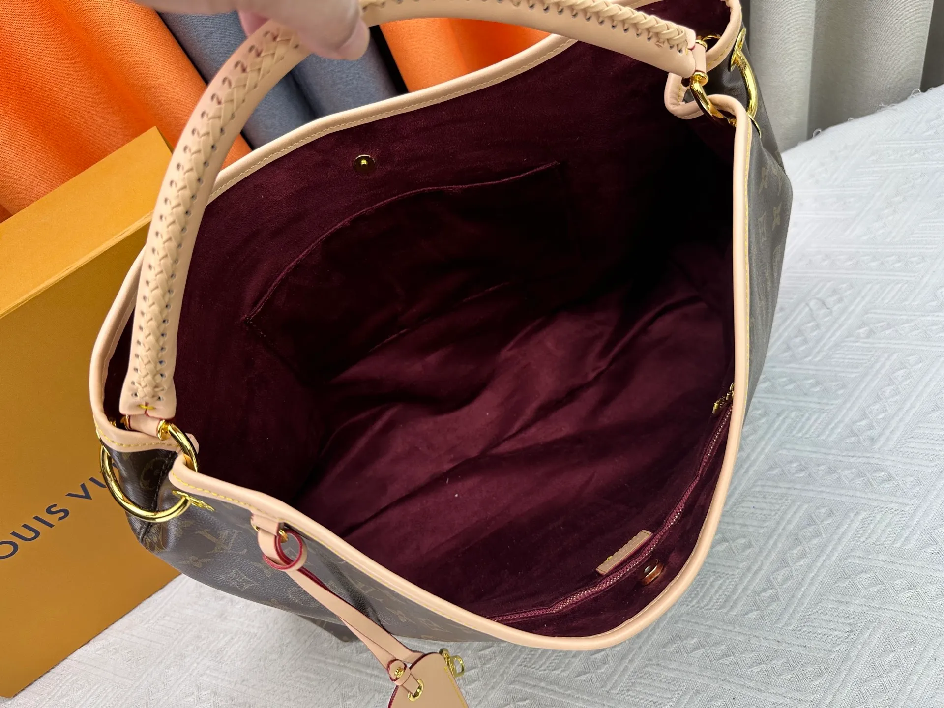 P300 upgrades the original M25877 Again bag, a new interpretation of the iconic Artsy design first launched in 2010, now more flexible, more iconic and more refined. Rooted in LV’s DNA, this bag pays homage to Louis Vuitton’s craftsmanship with its classic Monogram canvas base, hand-woven handles and customizable name tag. It's spacious enough to hold a laptop and opens to reveal multiple pockets. Gold hooks can be used to hang playful accessories! ! Size:50x30x15.5CM