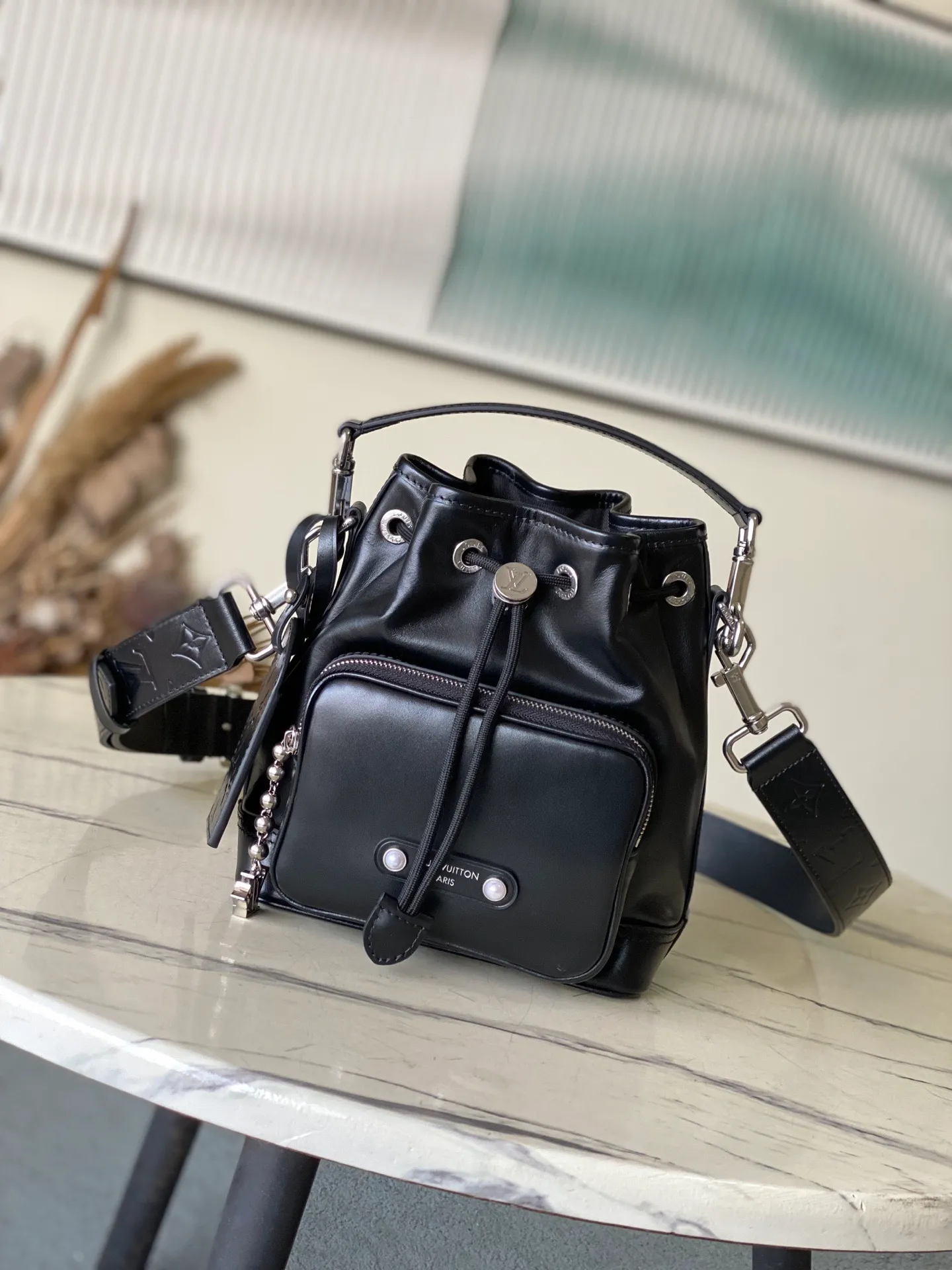 💰1260 (top-grain leather) Top original order M13985 This NoeCargo small bucket bag injects cow leather with a dazzling luster like nylon, and highlights the details with metal LV letters and bead chains. It is equipped with a spacious front pocket and a fabric lining. Dimensions: 22 × 24 × 16 cm