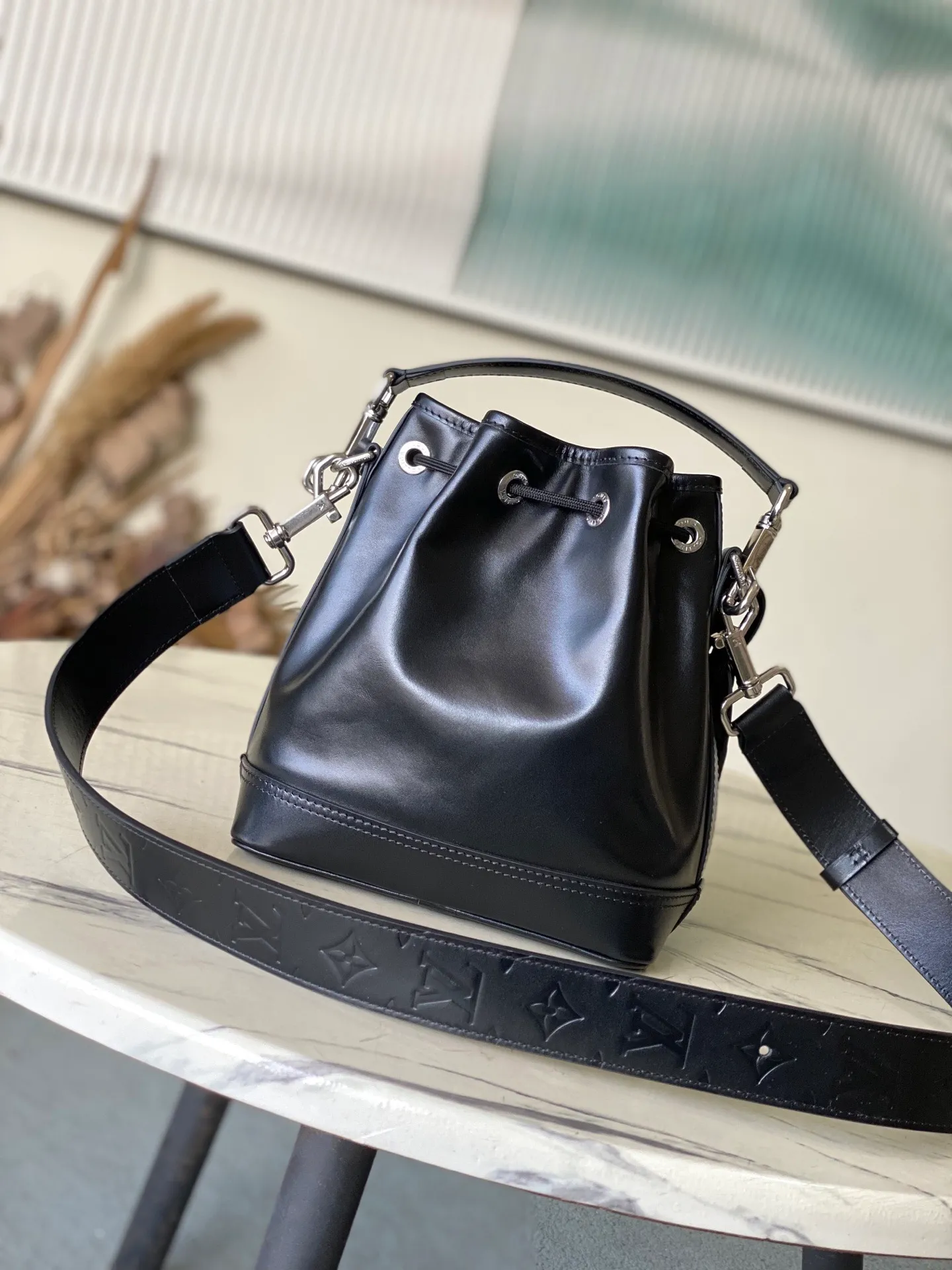 💰1260 (top-grain leather) Top original order M13985 This NoeCargo small bucket bag injects cow leather with a dazzling luster like nylon, and highlights the details with metal LV letters and bead chains. It is equipped with a spacious front pocket and a fabric lining. Dimensions: 22 × 24 × 16 cm