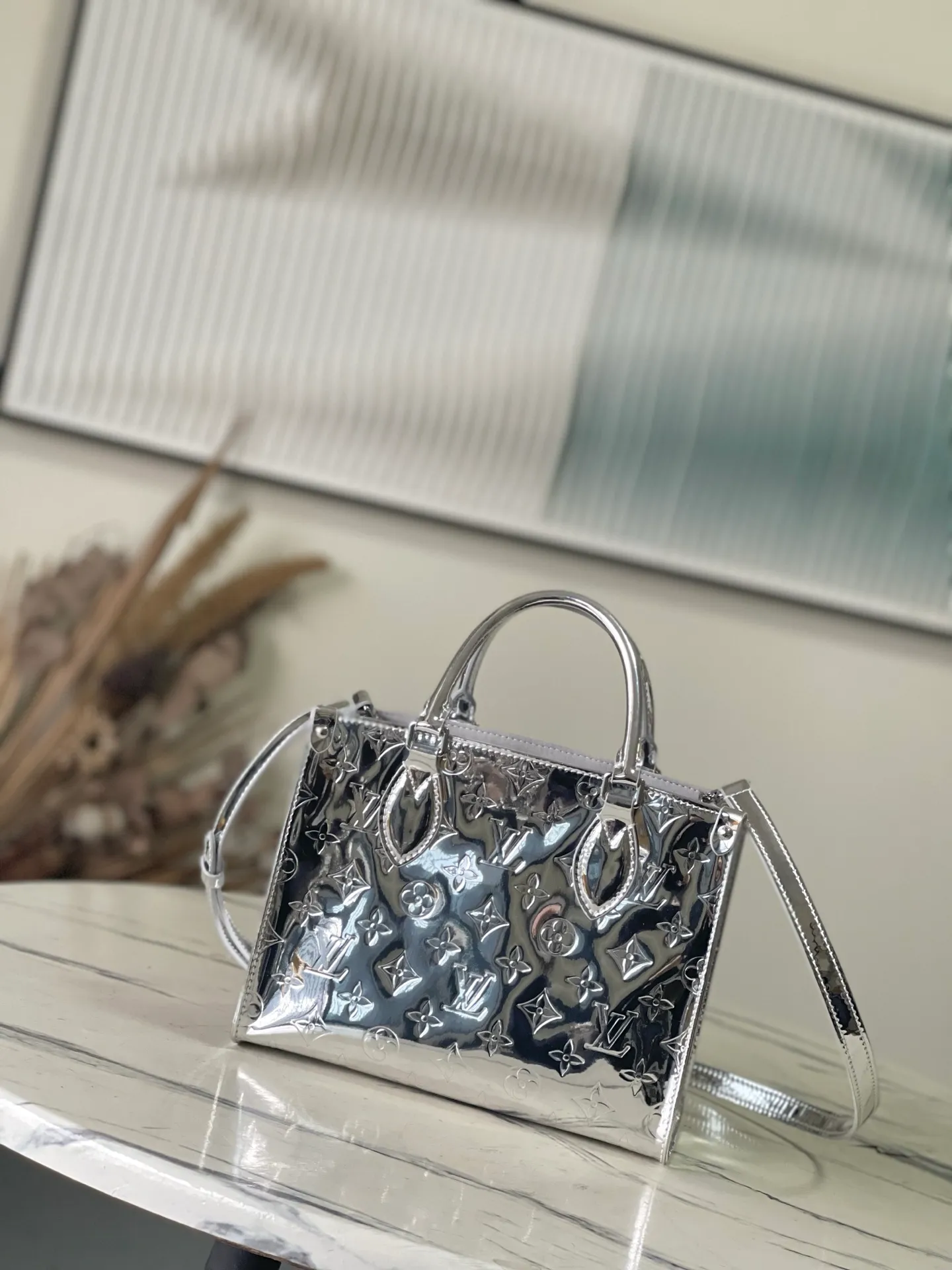 💰1120 Top Original M26373 Silver This OnTheGo small handbag joins the Ski series in the Monogram Miroir version. Laminated canvas ensures durability. Silver hues and tonal hardware create a gleaming look. Built-in pockets can store daily necessities such as small books. Size: 25*11.5*19cm.