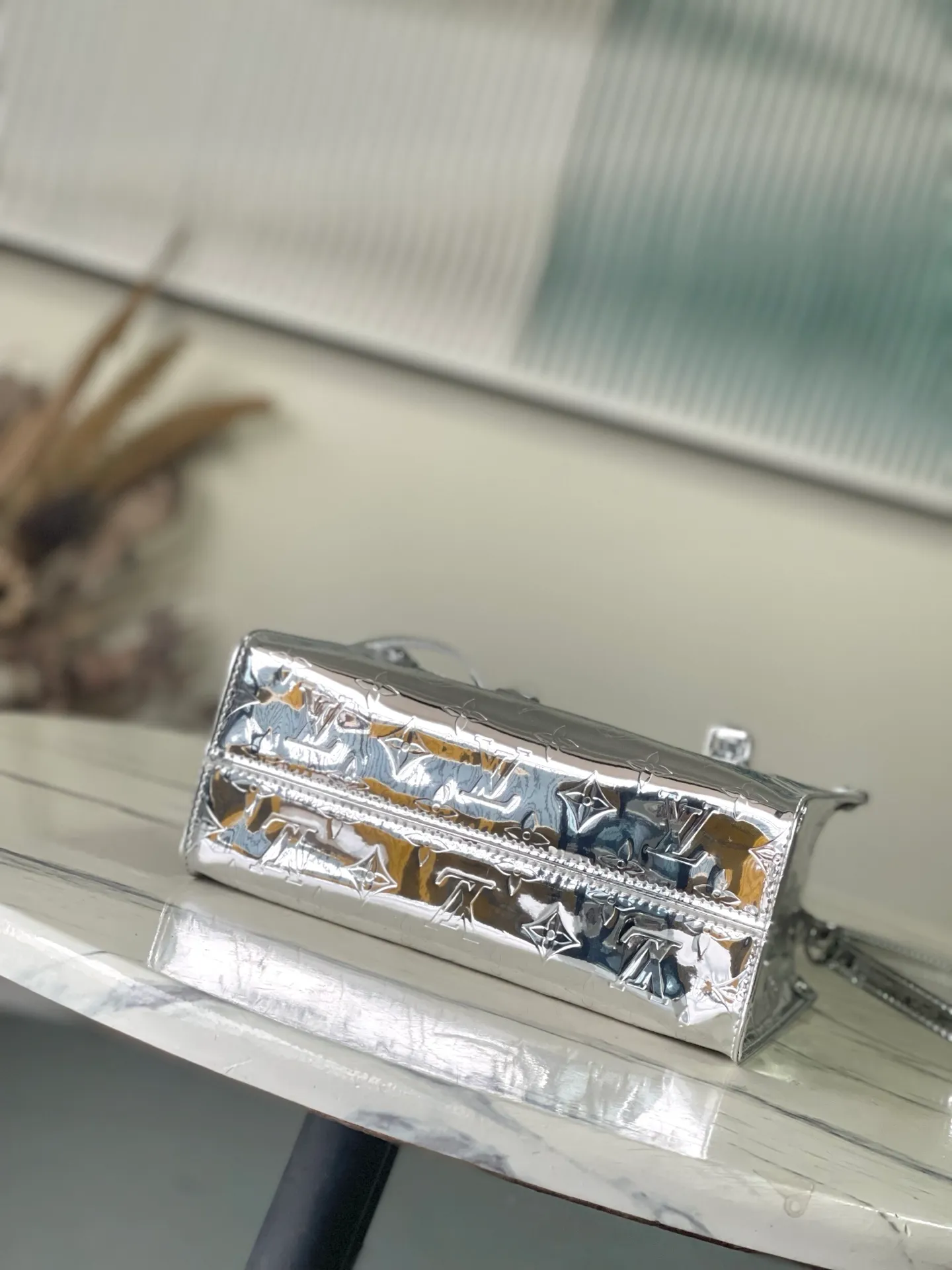 💰1120 Top Original M26373 Silver This OnTheGo small handbag joins the Ski series in the Monogram Miroir version. Laminated canvas ensures durability. Silver hues and tonal hardware create a gleaming look. Built-in pockets can store daily necessities such as small books. Size: 25*11.5*19cm.