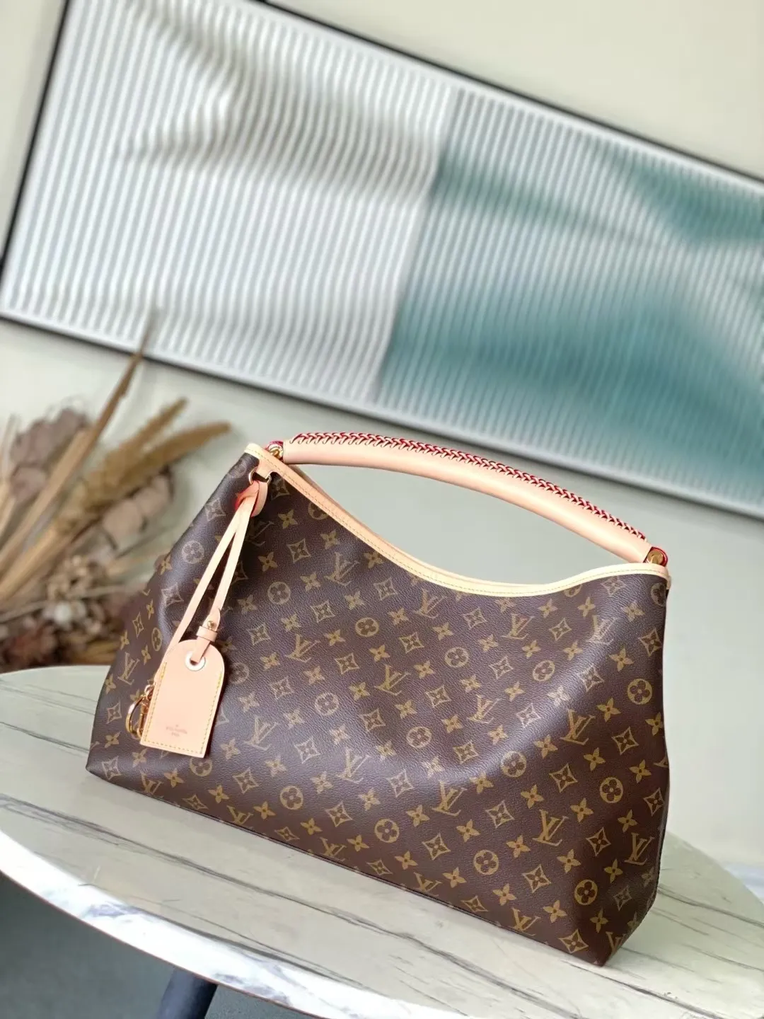 💰940 Top Original Order M25877 This Again bag is a current, more flexible and iconic reinterpretation of the Artsy model introduced in 2010. This finely crafted version is rooted in the house's heritage and pays homage to its expertise with Monogram canvas, hand-braided handles and customizable address holders. The room is large enough to accommodate a laptop and has lots of pockets. A gold carabiner allows you to add a playful touch to it. Dimensions: 53x30x15.5cm (LxHxW)